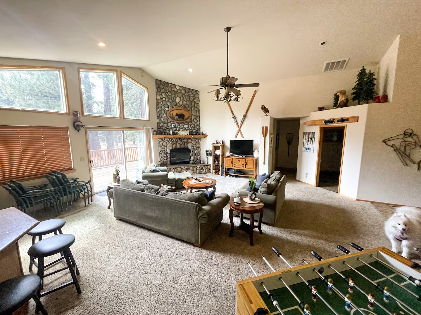 Luxury cabin large open floor plan living room with sofas, bar seating, Native American art and foosball table.