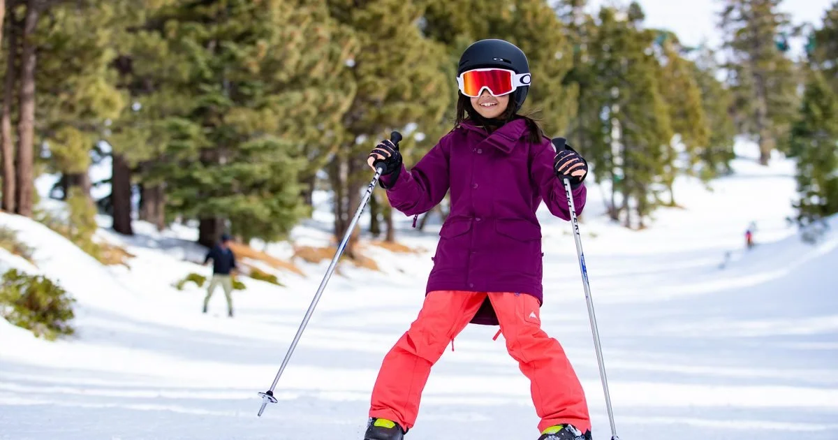 Child snow skiing down beginner slope.