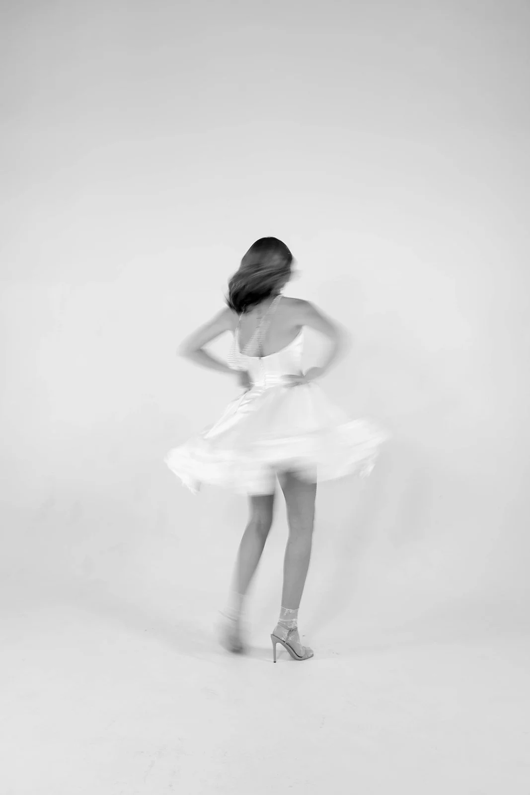 Bride spinning in a short tulle wedding reception dress, motion blur capturing movement and playful bridal energy.