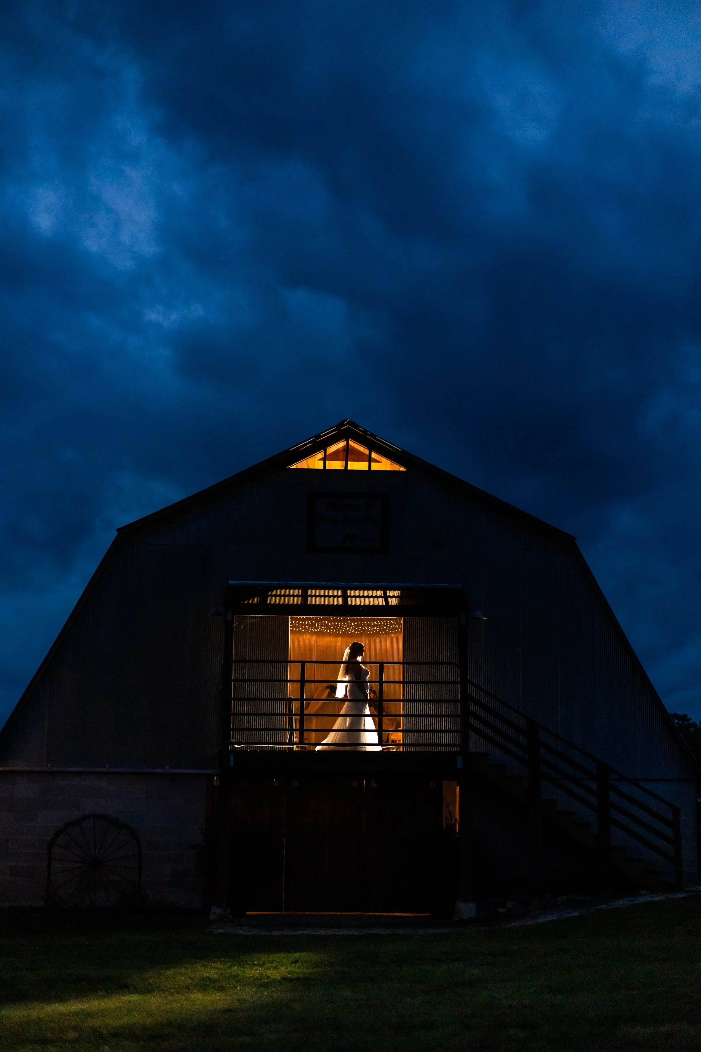 Moody Silhouette of bride in barn