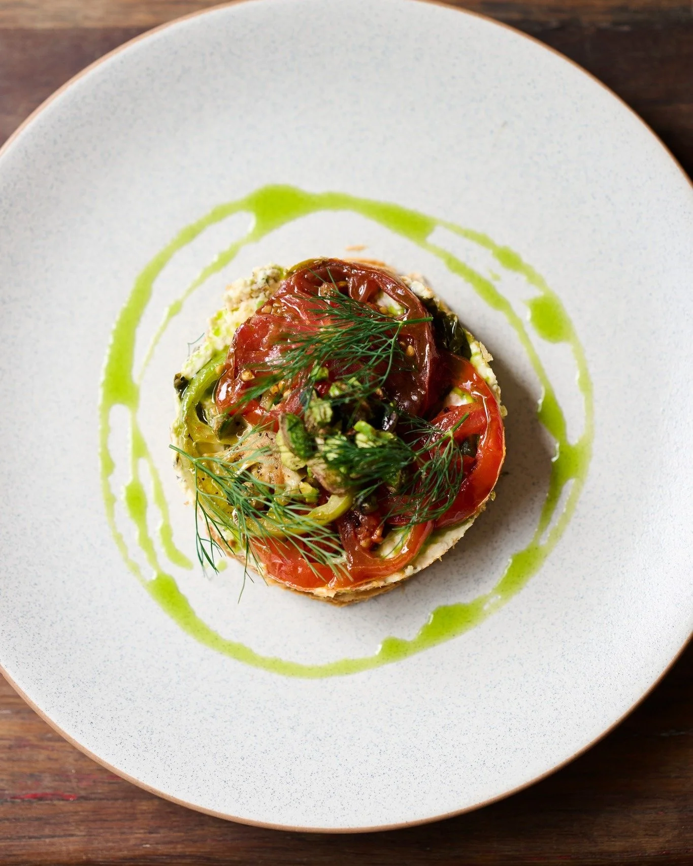 Pepe Saya puff, heirloom tomato, pistachio stracciatella, tarragon oil, caper leaf.