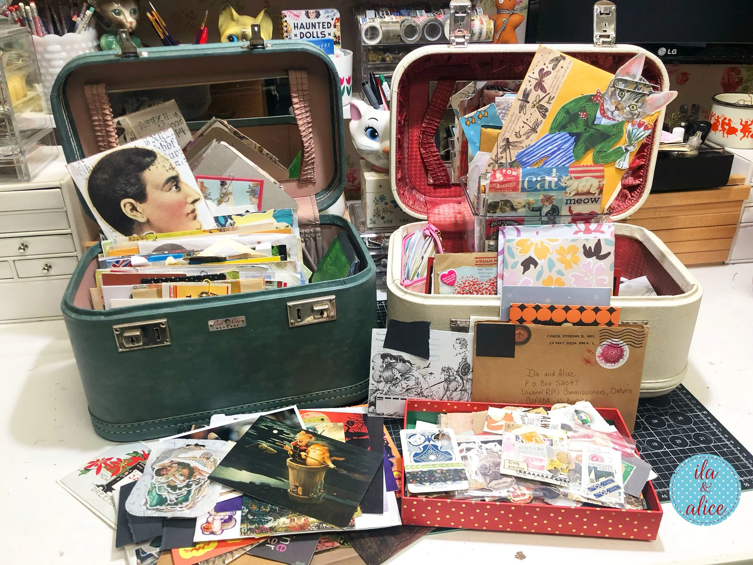 Two vintage suitcases and a tray filled with happy mail, cards, postcards, envelopes, and paper treasures during a craft room organization project.