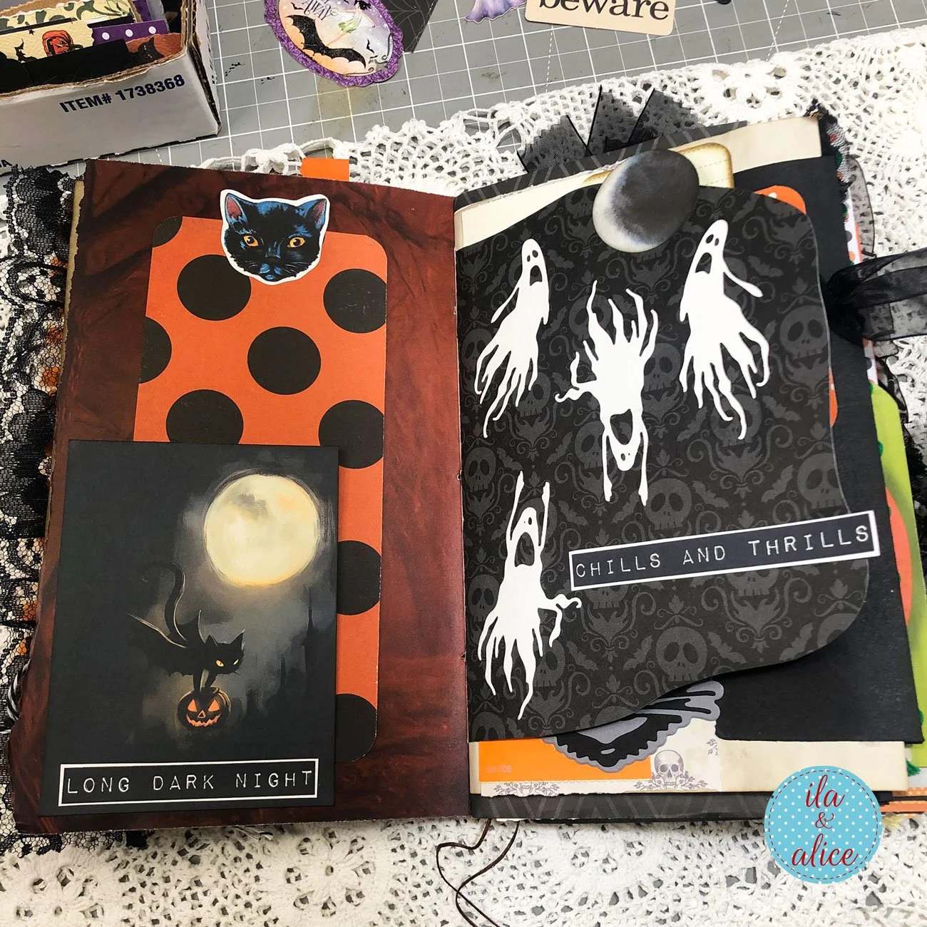 Interactive Halloween junk journal spread with a large illustrated hand, orange polka-dot pocket, black cat and oversized Halloween tag