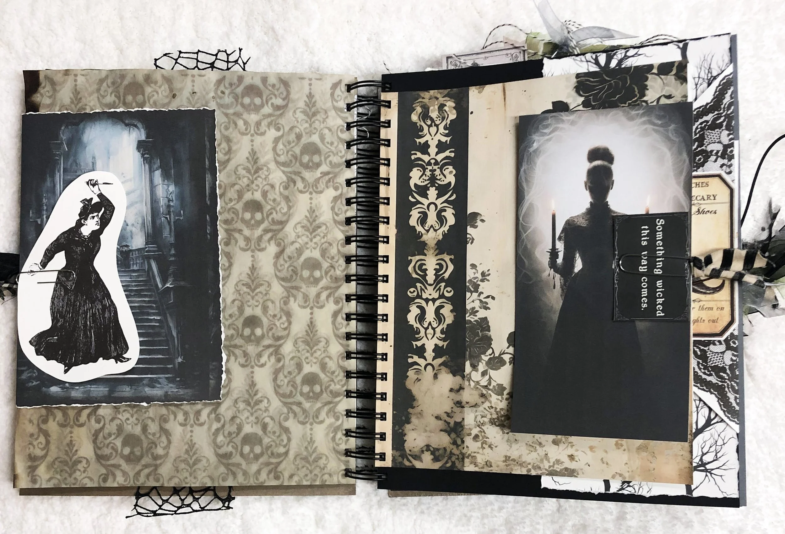 Open witch junk journal with a dark doorway, Victorian woman, skull damask paper and candlelit silhouette.