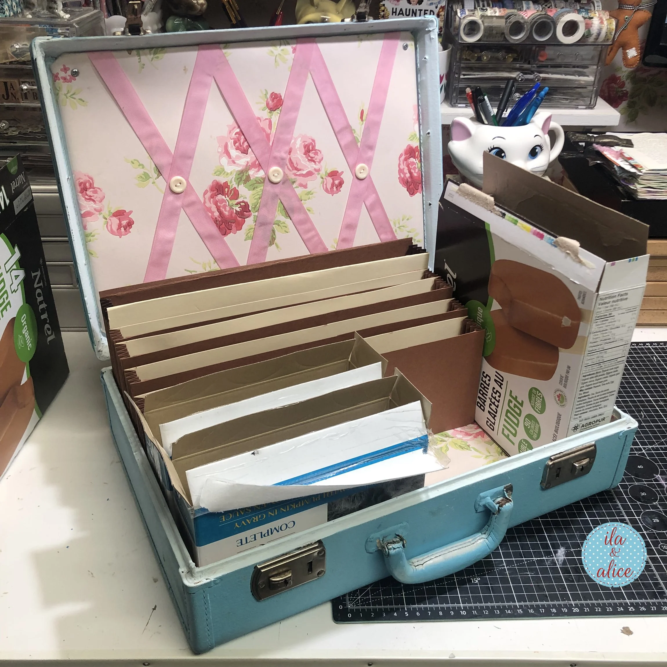 Vintage blue suitcase with handmade cardboard dividers being arranged inside to organize happy mail, postcards, cards, and paper keepsakes.