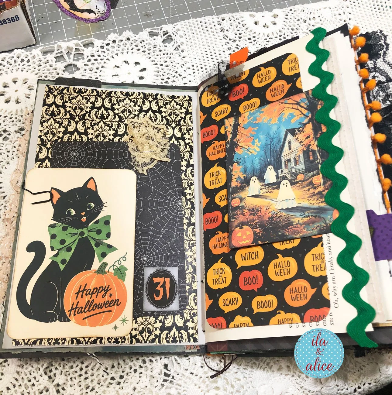 Open Halloween junk journal spread featuring a vintage black cat, spiderweb pocket, friendly ghosts, pumpkins and green rickrack
