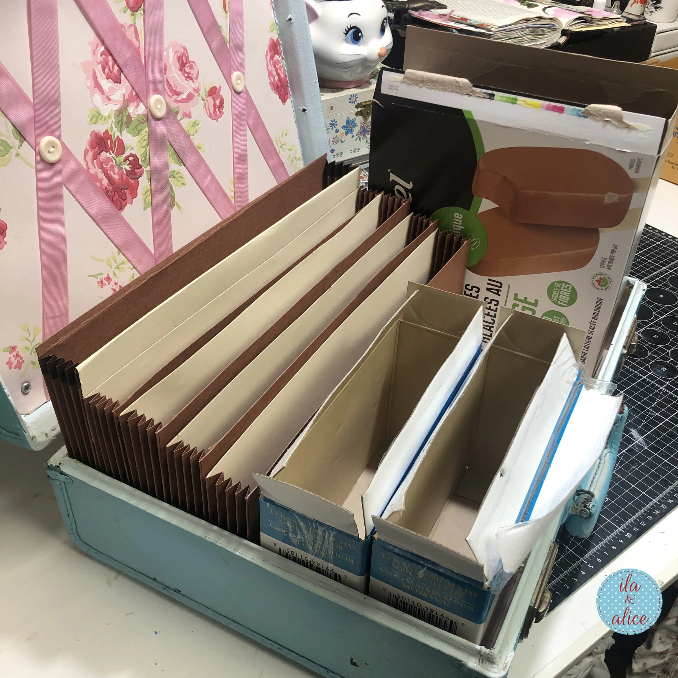 Close-up of accordion-style cardboard dividers and handmade storage sections inside a vintage suitcase for organizing happy mail and paper ephemera.