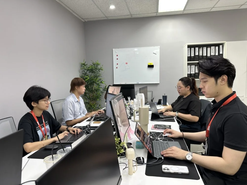 คนห้าคนกำลังทำงานบนแล็ปท็อปในห้องประชุมสำนักงานที่ทันสมัยพร้อมไวท์บอร์ดและตู้เก็บเอกสาร