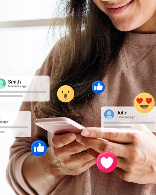A woman is holding a smartphone, and social media reactions like thumbs up, love, and surprised emojis are floating around her.