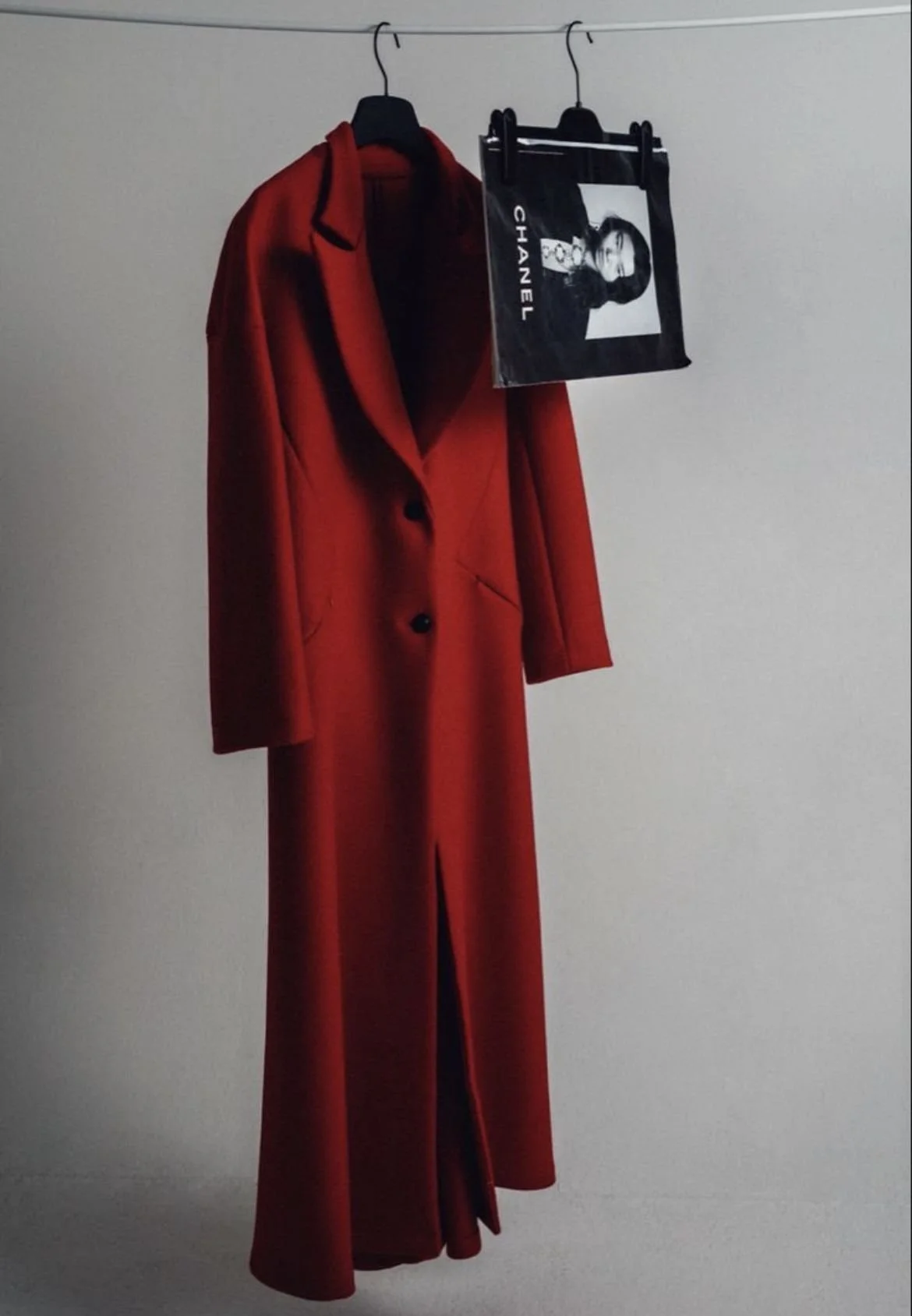A structured red wool coat styled with a black-and-white fashion visual — combining timeless wardrobe staples with high-fashion influence in personal styling.