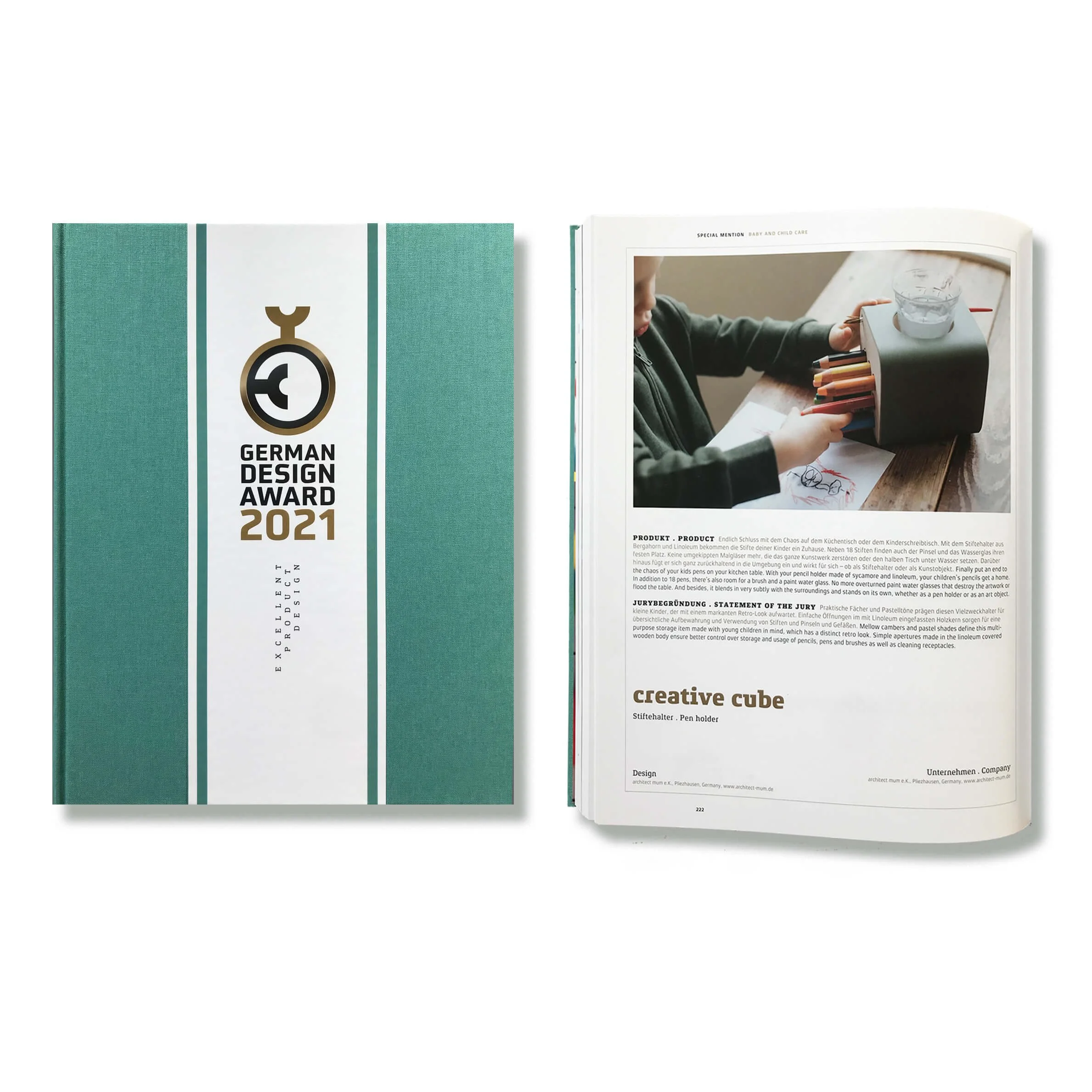 Ein Buch mit dem Titel 'German Design Award 2021' und ein geöffnetes Magazin, das eine Person zeigt, die an einem Tisch sitzt und an einem kreativen Projekt arbeitet.