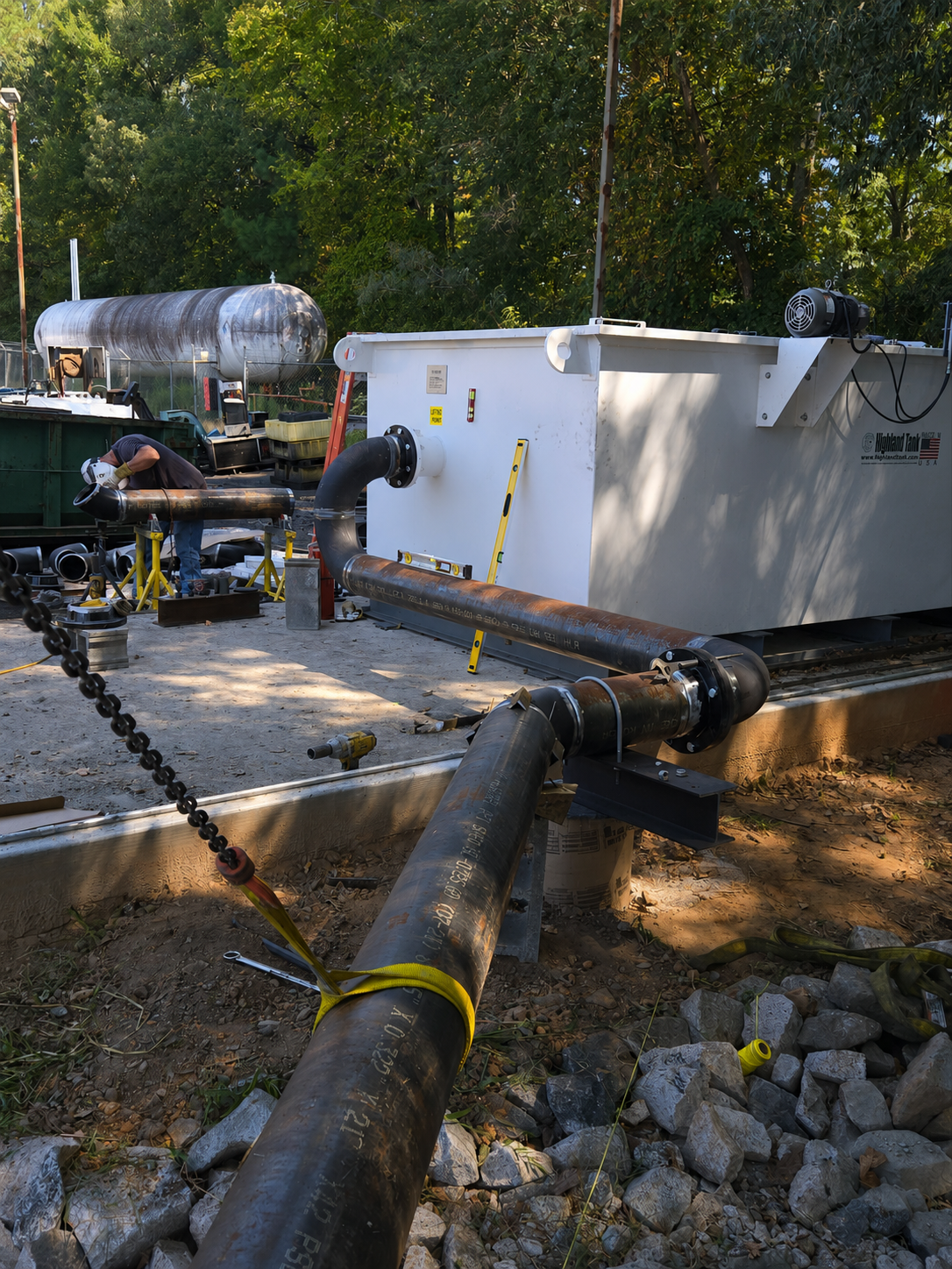 Large-diameter carbon steel process piping connected to an industrial storage tank, showcasing precision pipe fabrication and mechanical installation at the FOMAS industrial facility by Melting Point LLC in SC.