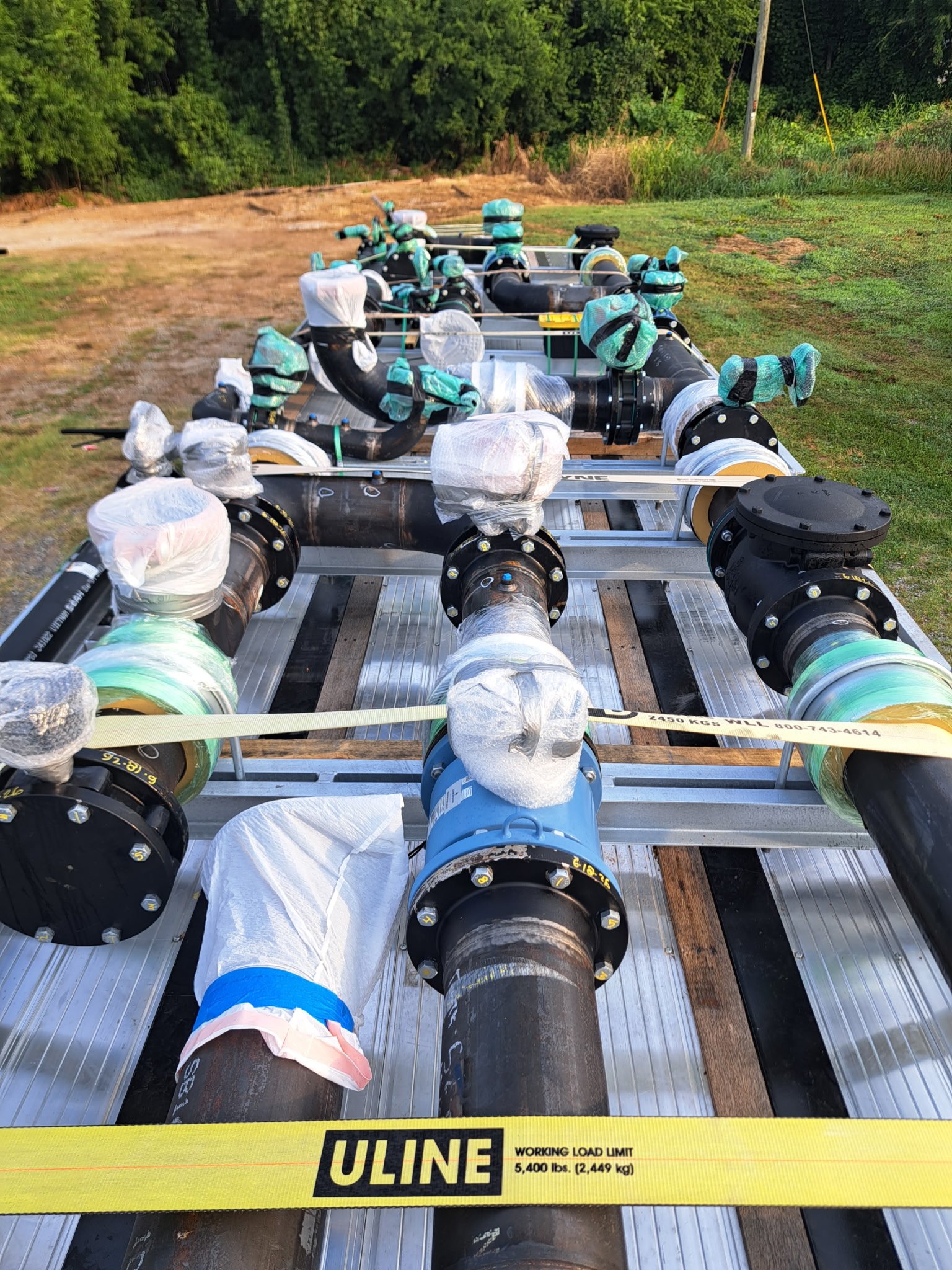 Completed custom steel piping assemblies are secured for transport by Melting Poing LLC after fabrication and quality preparation for the McKenney industrial piping project.