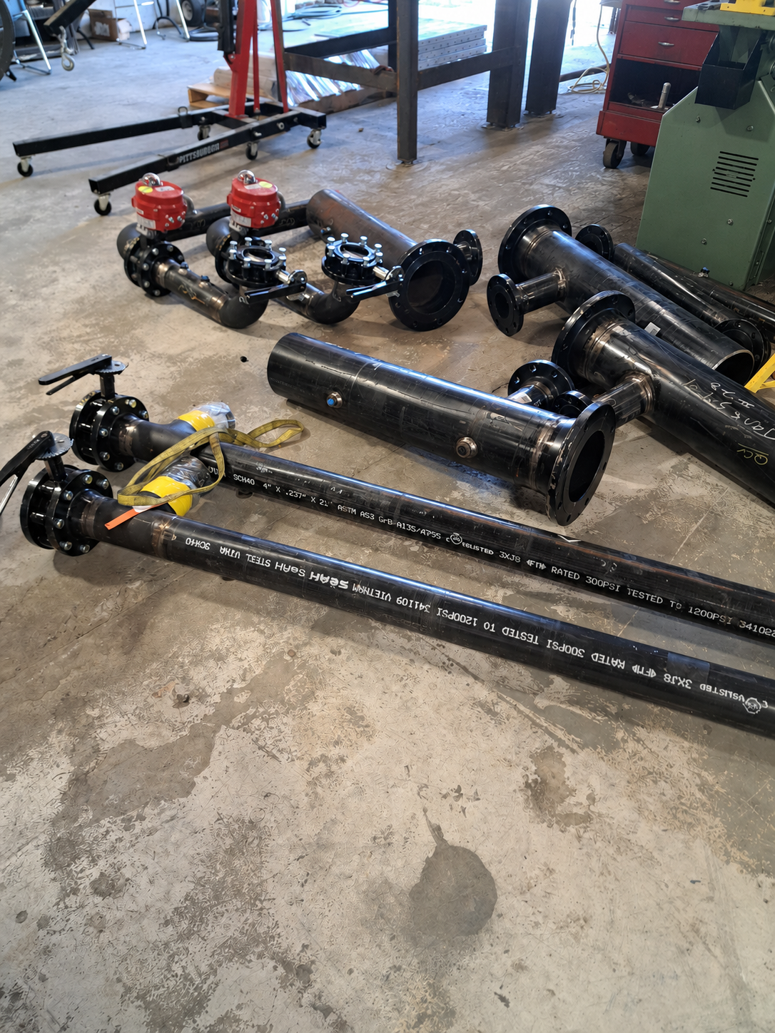 Fabricated carbon steel pipe spools with flanges and valves are staged in the Melting Point fabrication shop before final assembly and installation for the McKenney project.
