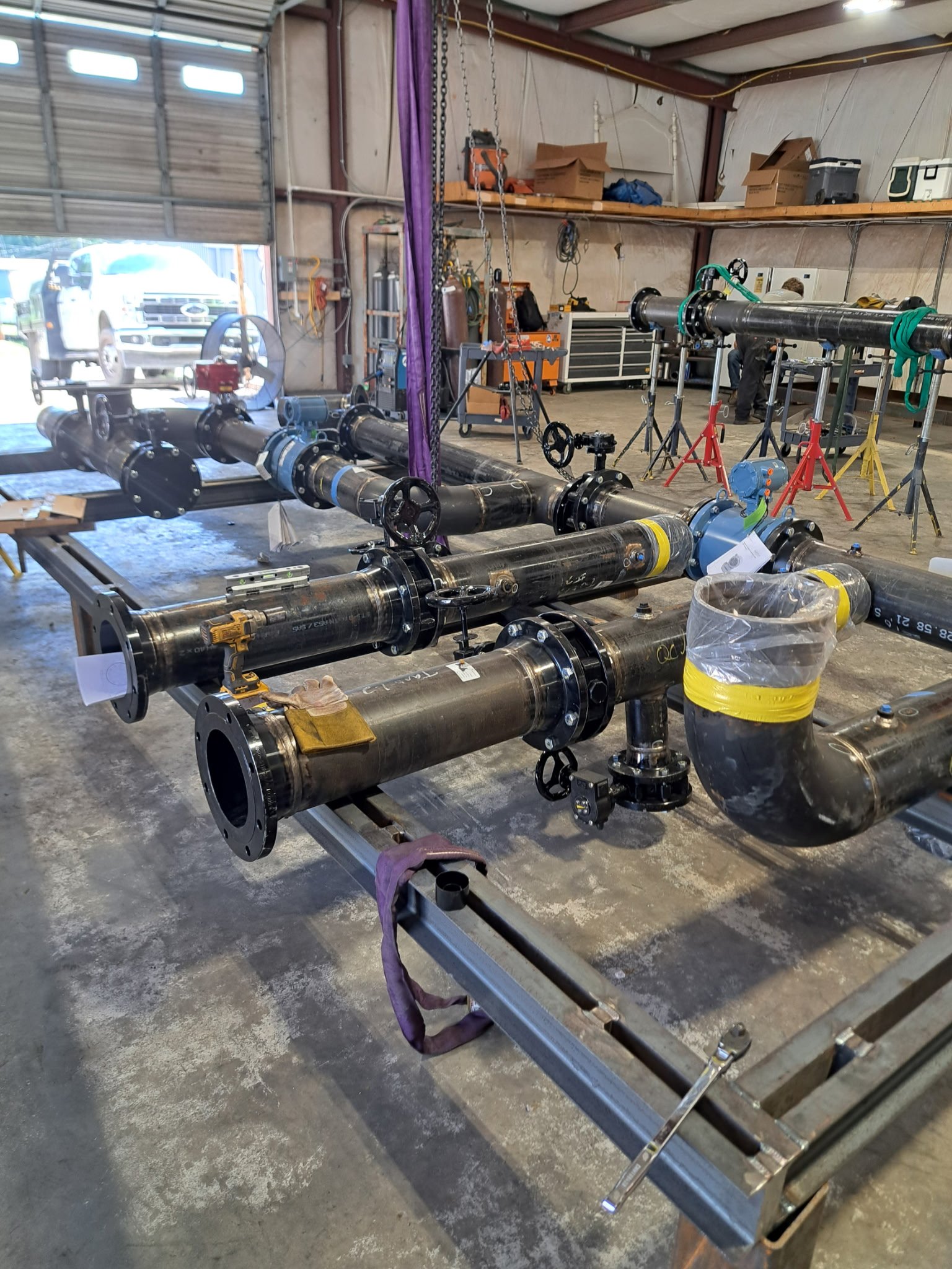 Large custom industrial piping systems are assembled and fitted in the Melting Point LLC fabrication shop as part of the McKenney project, showcasing precision welding and structural fabrication.