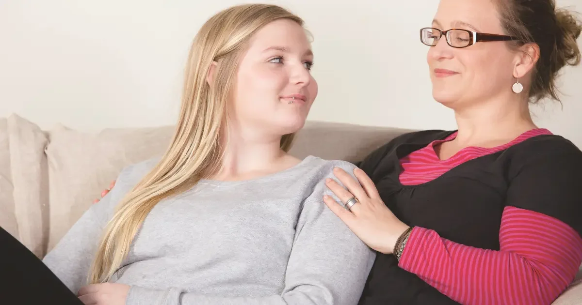 A mother who is recovering from parental burnout sitting with their teen daughter.