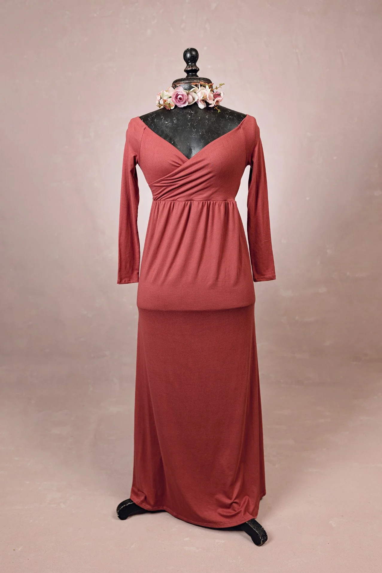 A maroon red stretchy fabric dress with floor length skirt, wrap v-neck upper, and long sleeves