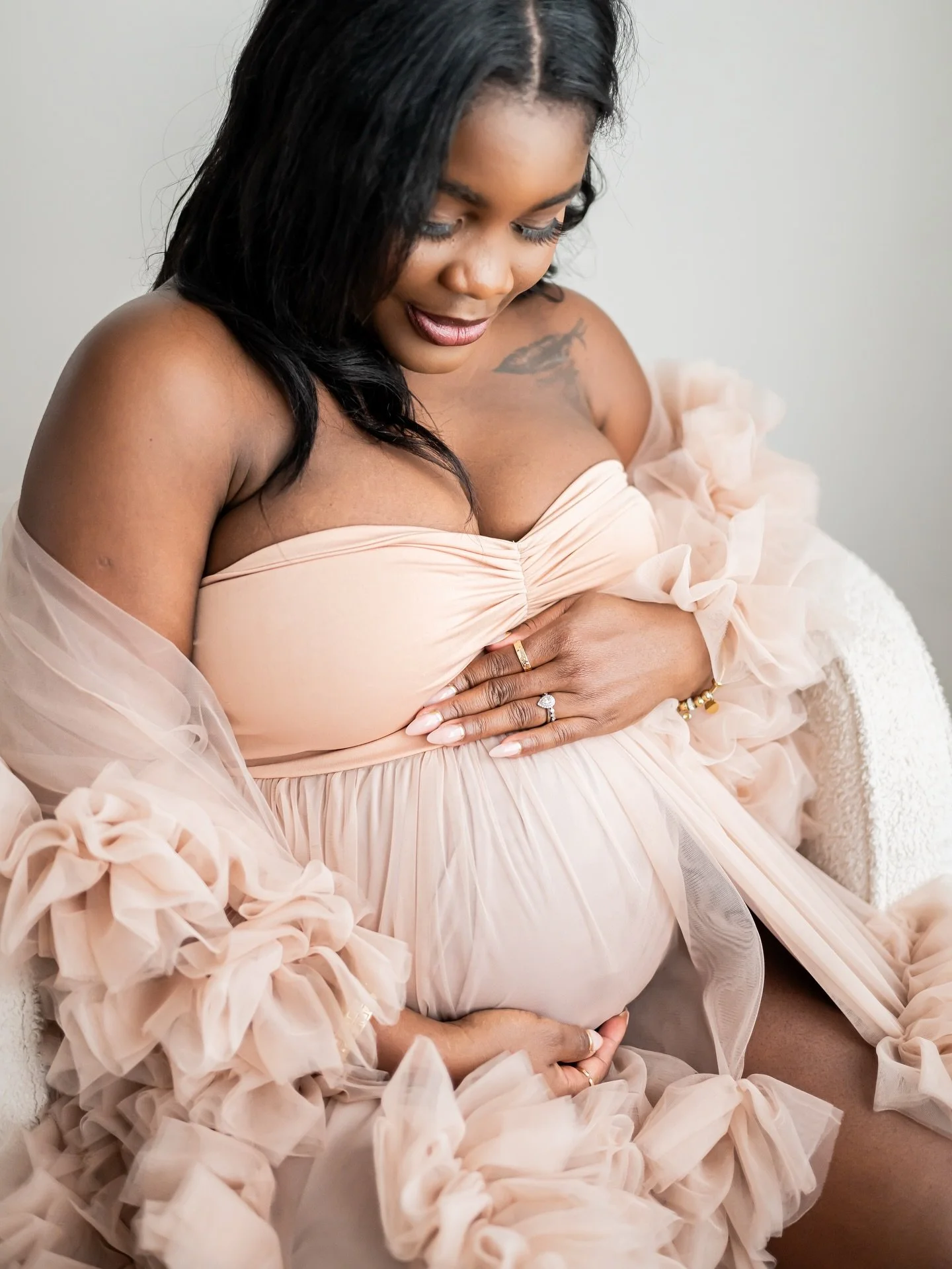 Portrait of a pregnant woman wearing a ruffled tulle dusty rose gown, in Calgary maternity studio session