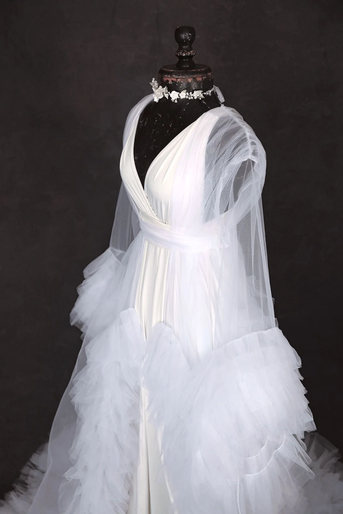 Close up of white infinity dress, with a sheer white tulle robe, and silver jewellery ribbon