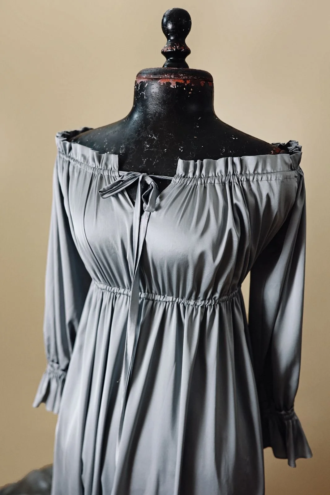 Close up of silky grey gown, showing off-shoulder strapless desing