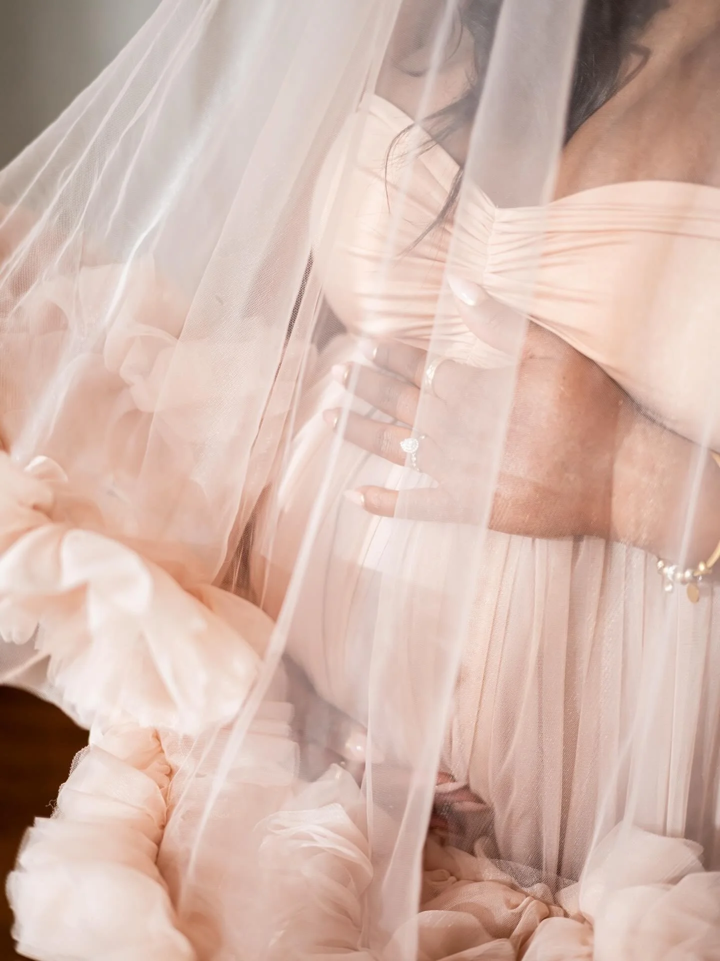 Close up of tulle maternity gown, showing sheer tulle and baby bump