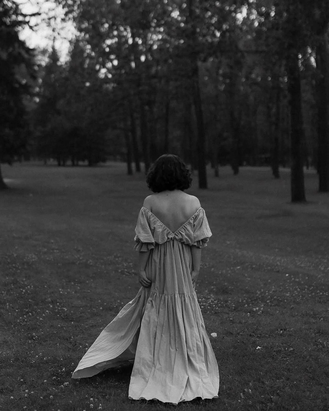 A woman wearing a light pink boho dress with an open back in an outdoor photoshoot in Calgary