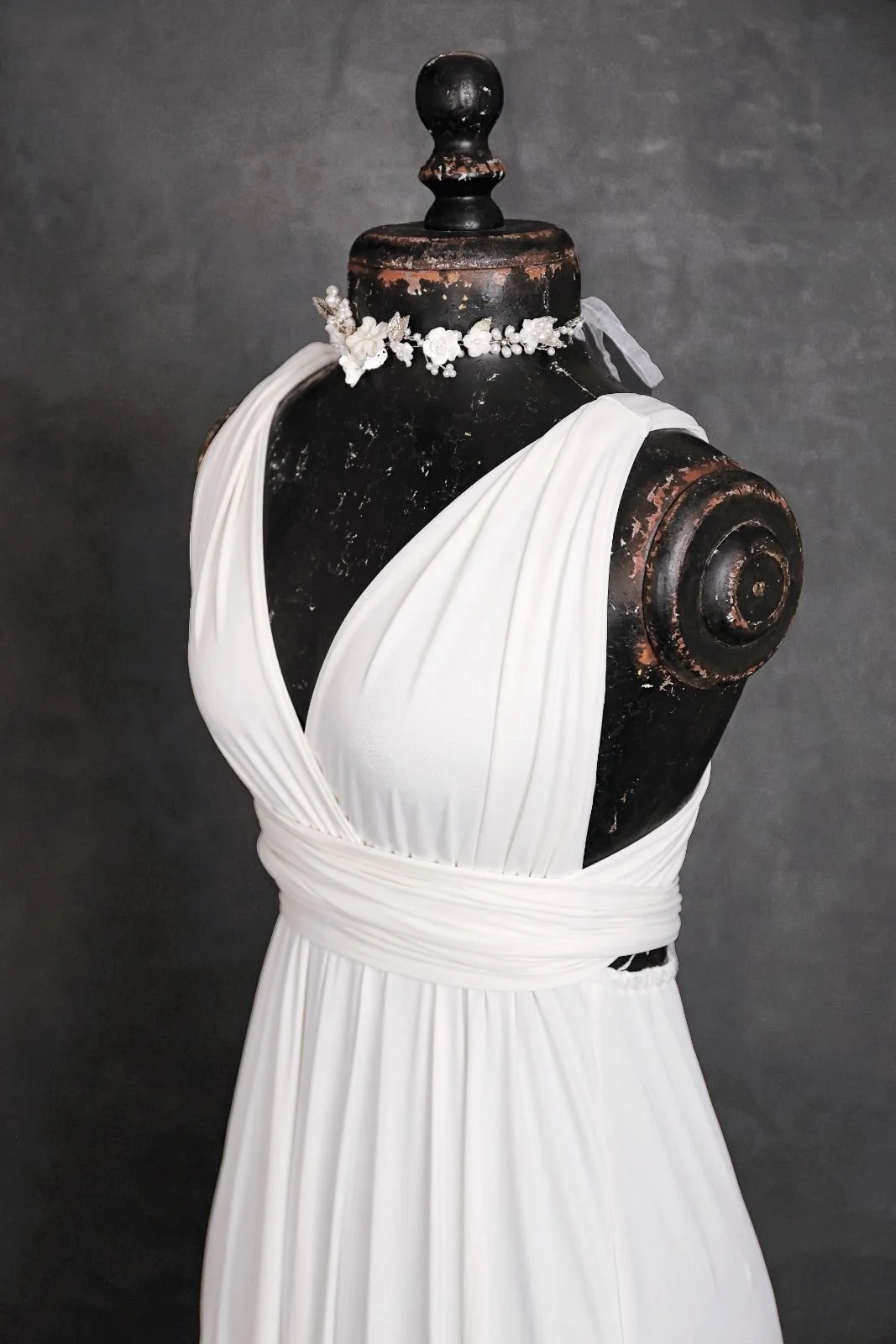 Close up of white maternity and engagement infinity dress, with silver jewellery ribbon