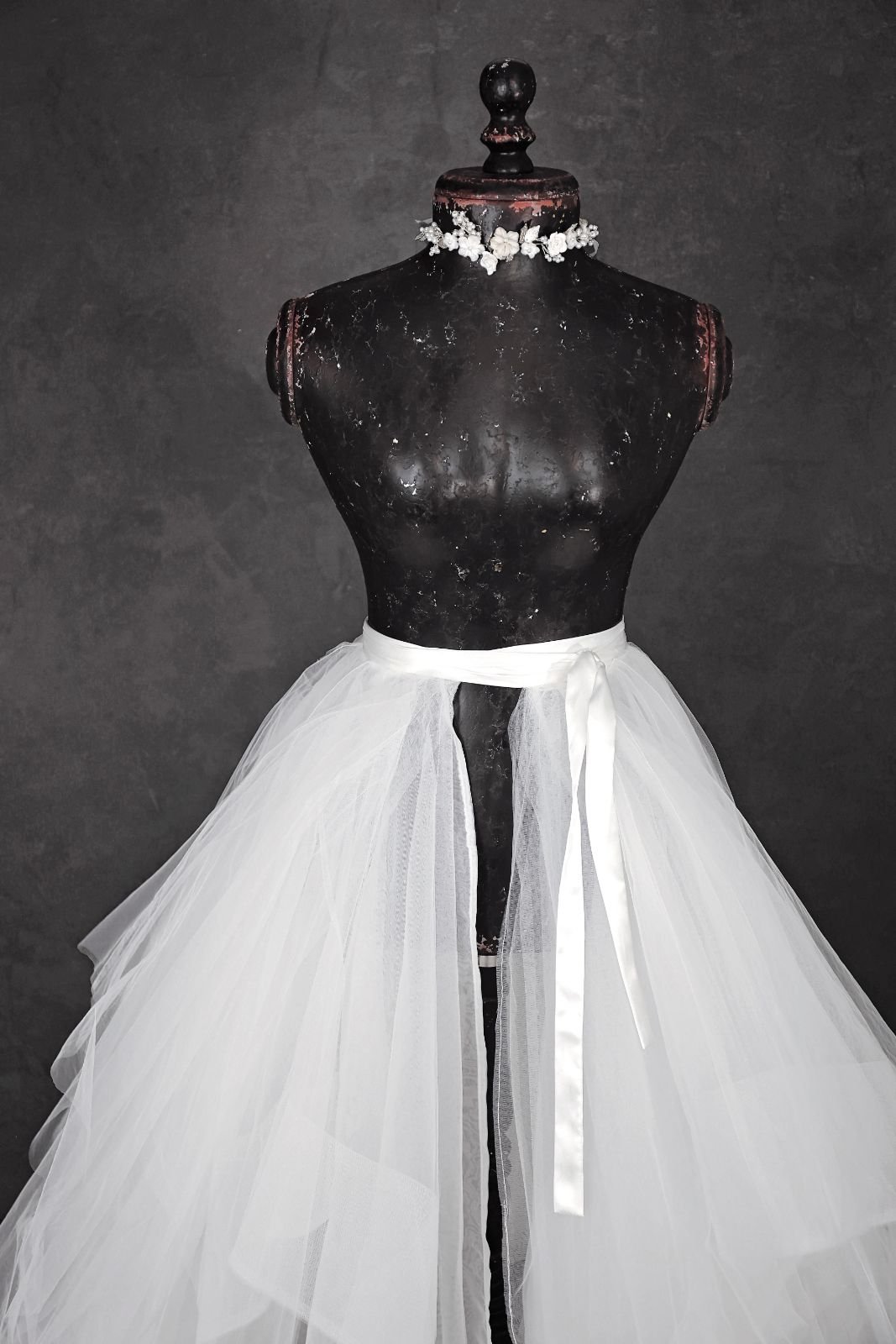 Close up of white layered tulle skirt and silver jewellery ribbon