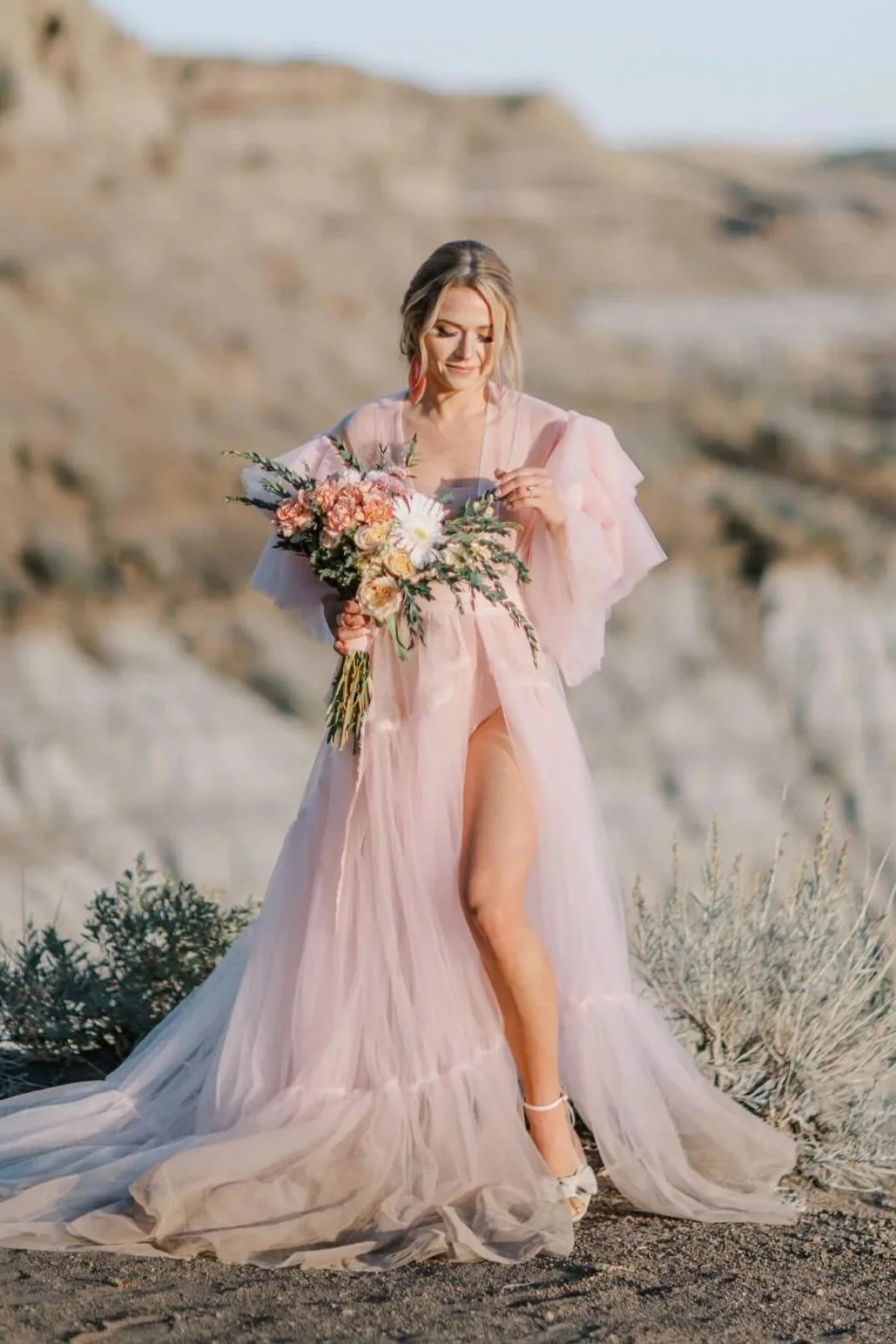 A woman with a bouquet of flowers in an outdoor engagement photoshoot in Calgary Drumheller