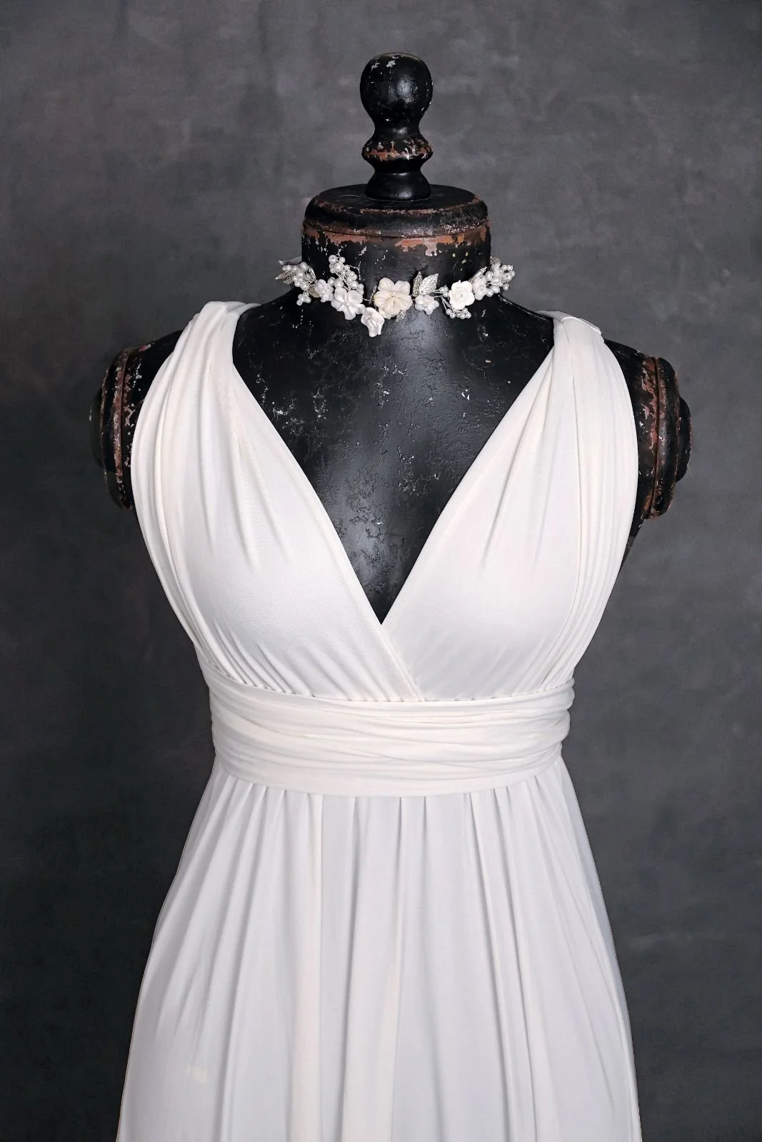 Close up of white maternity and engagement infinity dress, with silver jewellery ribbon