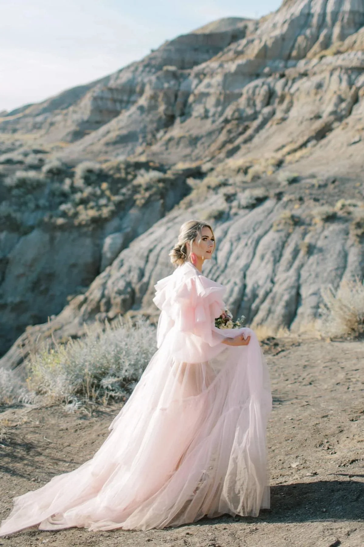 A woman with a bouquet of flowers in an outdoor engagement photoshoot in Calgary Drumheller