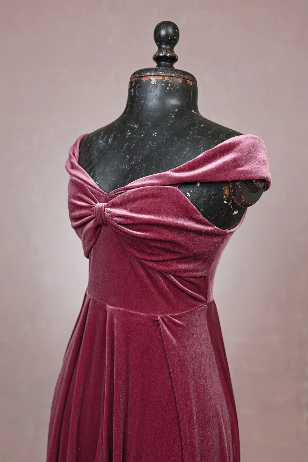 Close-up of maternity rental rose velvet dress, showing bowtie bodice and off-the-shoulder neckline