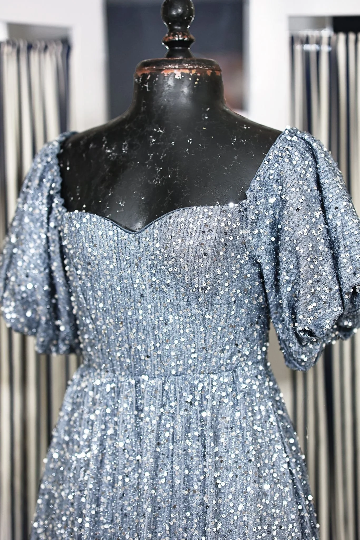Close up of light blue sequin dress with floor-length skirt and puffy sleeves, for maternity or couples photoshoots