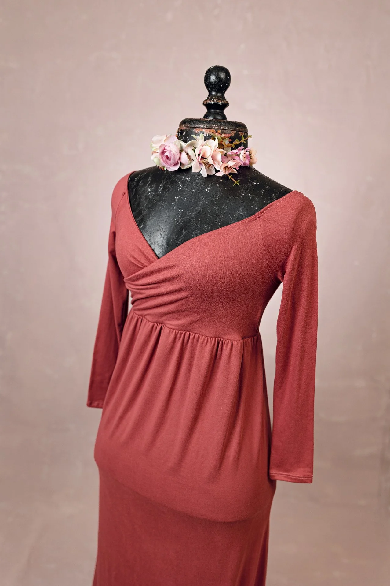 Close up view of maroon red stretchy fabric dress showing wrap v-neck upper and long sleeves