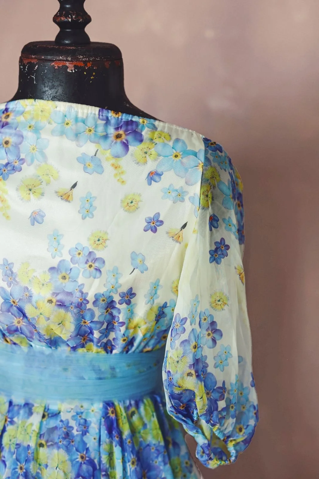 Close up view of a white maxi dress chest, showing blue and yellow floral print