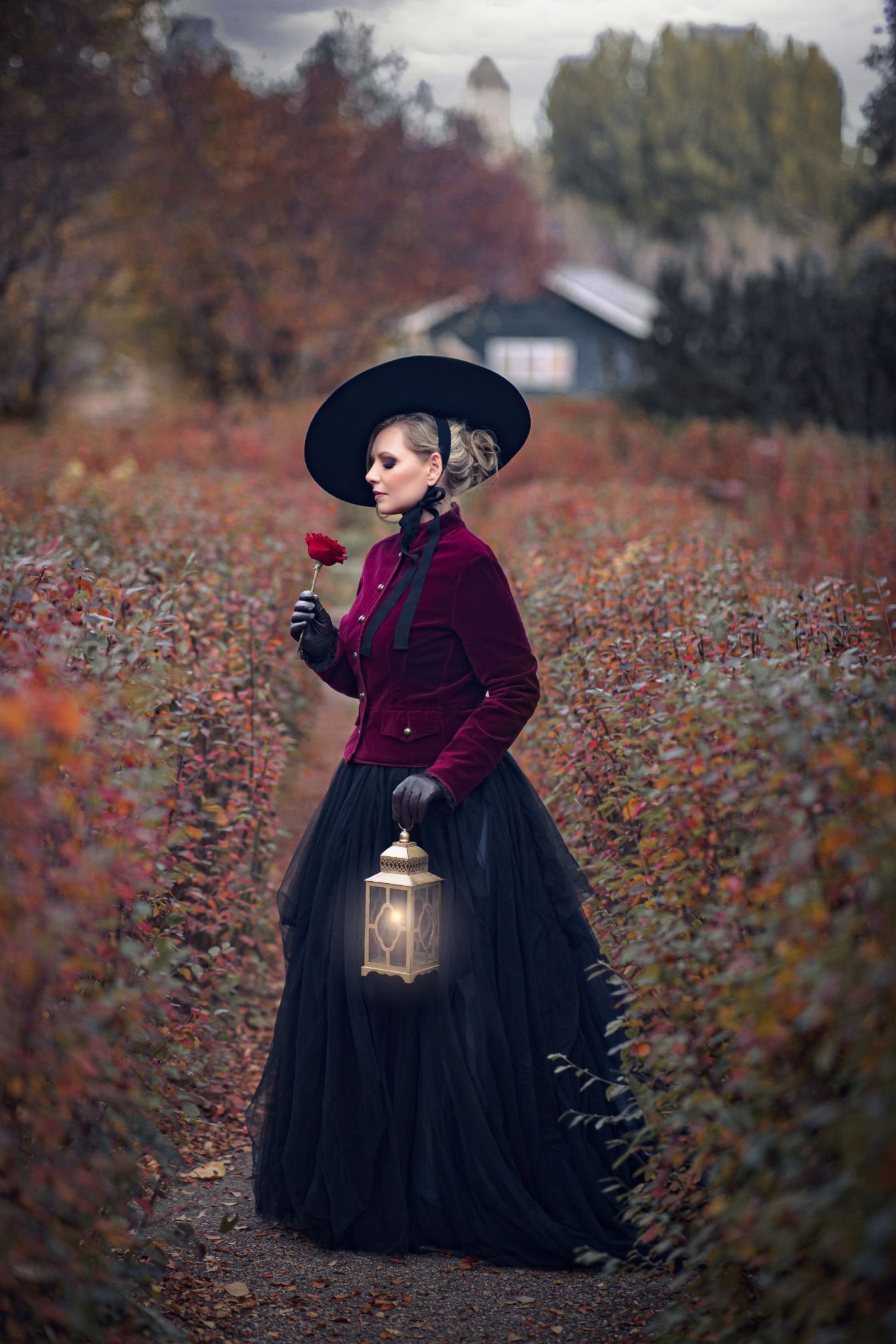 Woman wearing a black skirt and red velvet jacket in autumn Calgary outdoor photoshoot