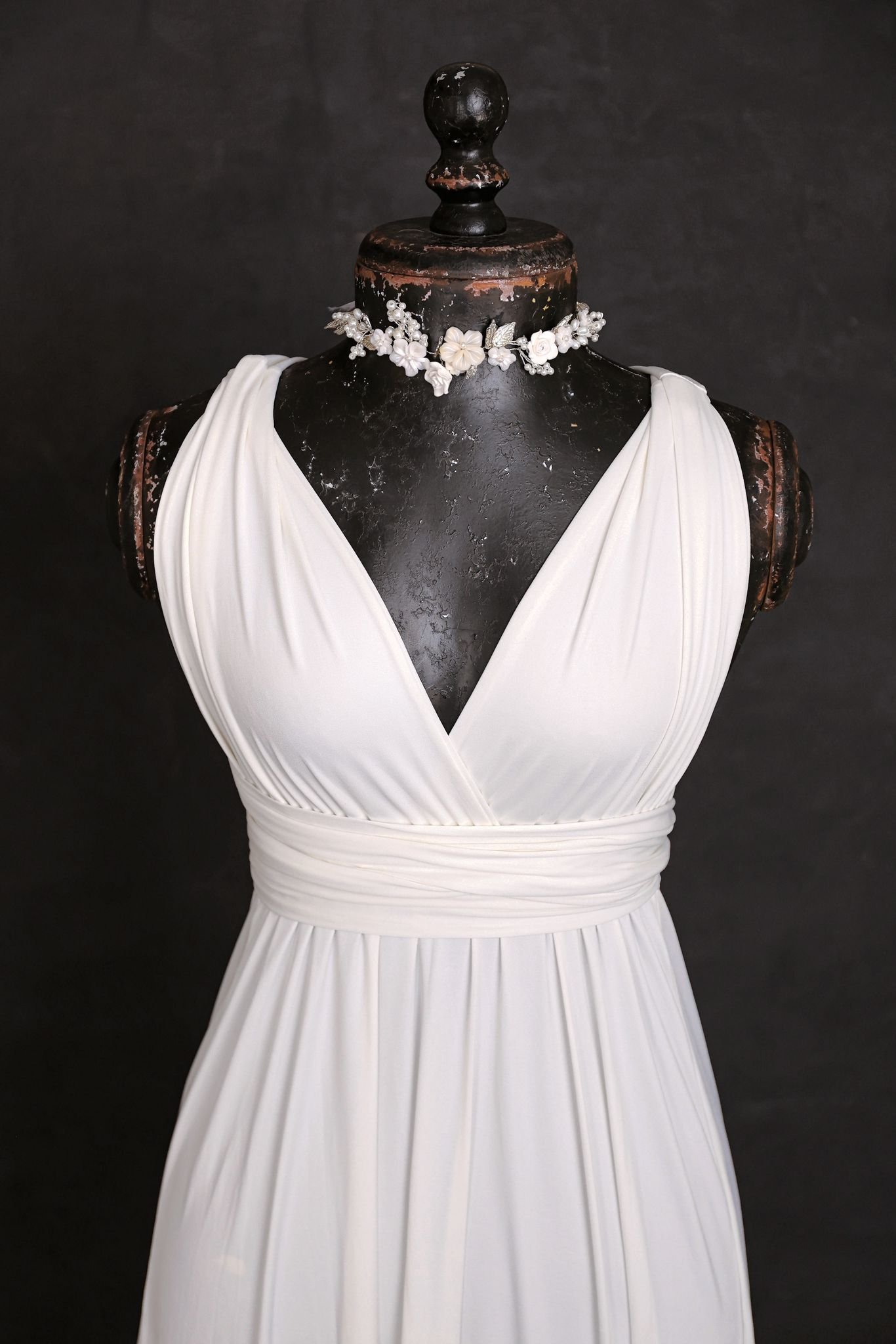 Close up of white maternity and engagement infinity dress, with silver jewellery ribbon