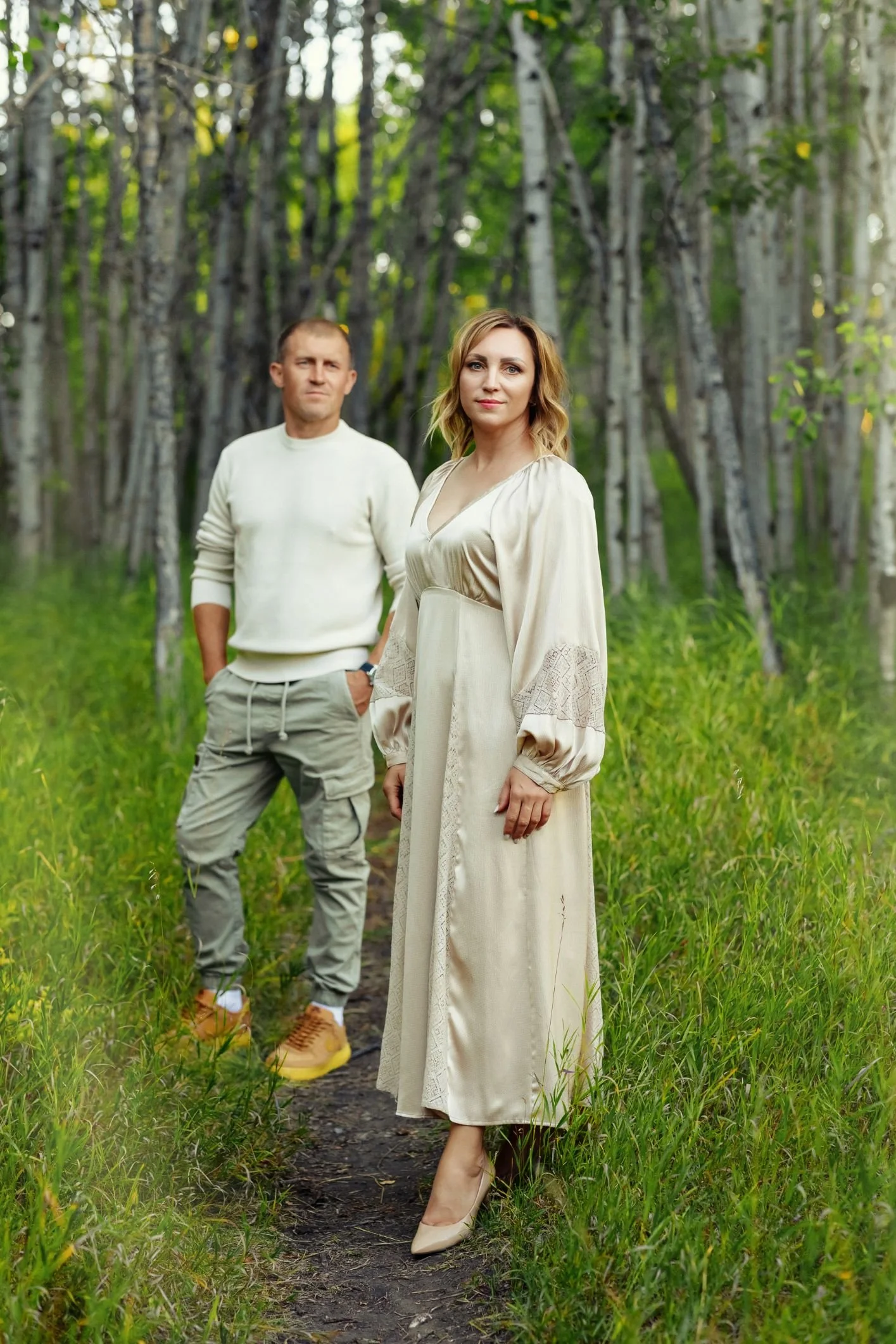 A woman in an outdoor family photoshoot, wearing a champagne coloured satin vintage boho dress