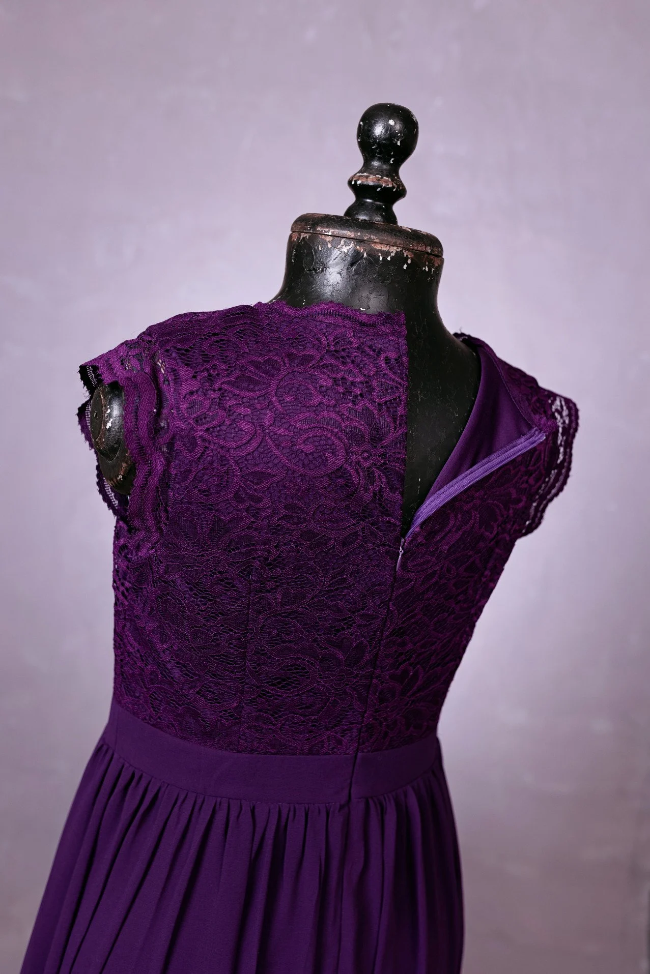 Back view of dark purple sleeveless dress with lace corset and soft flowing skirt, for rent in Calgary