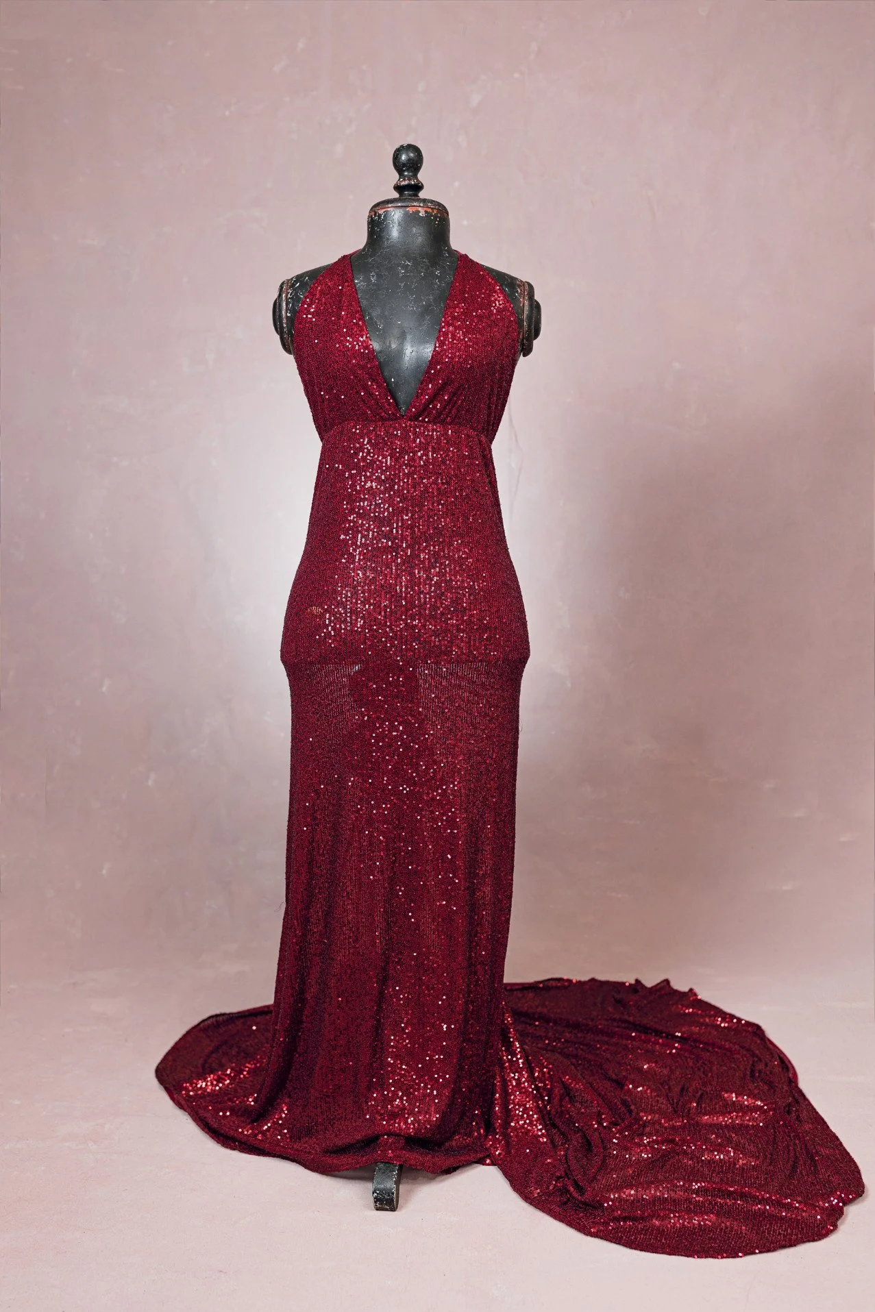 Red sparkly sequin form-fitting designer gown with v-neck, open halter back, and floor-length long train, for rent in Calgary