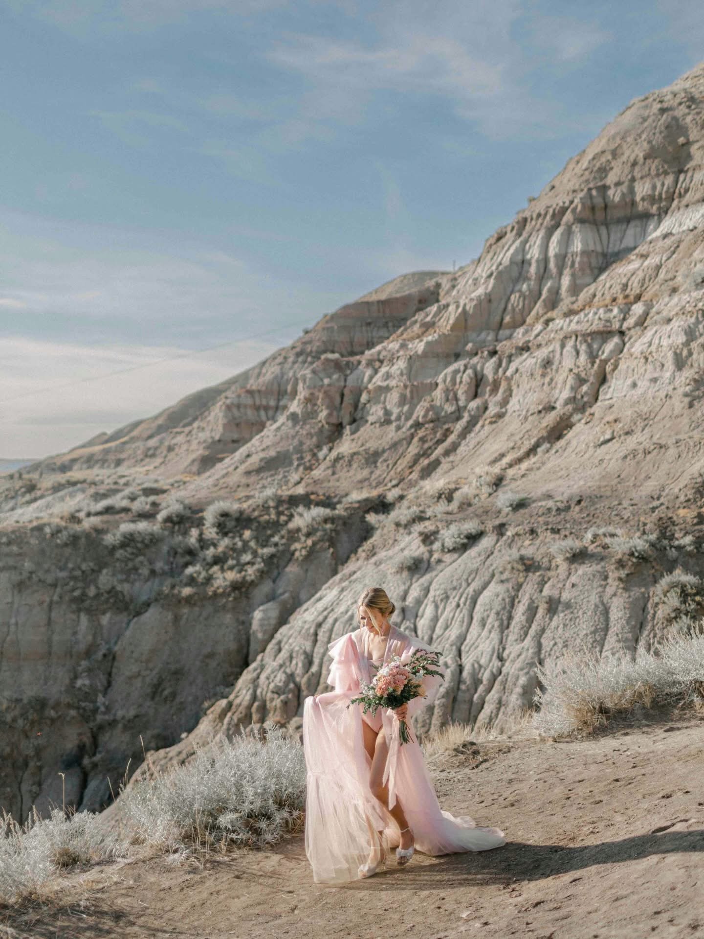 A woman in Drumheller Alberta wearing a fluffy pink gown robe to a bridal photoshoot