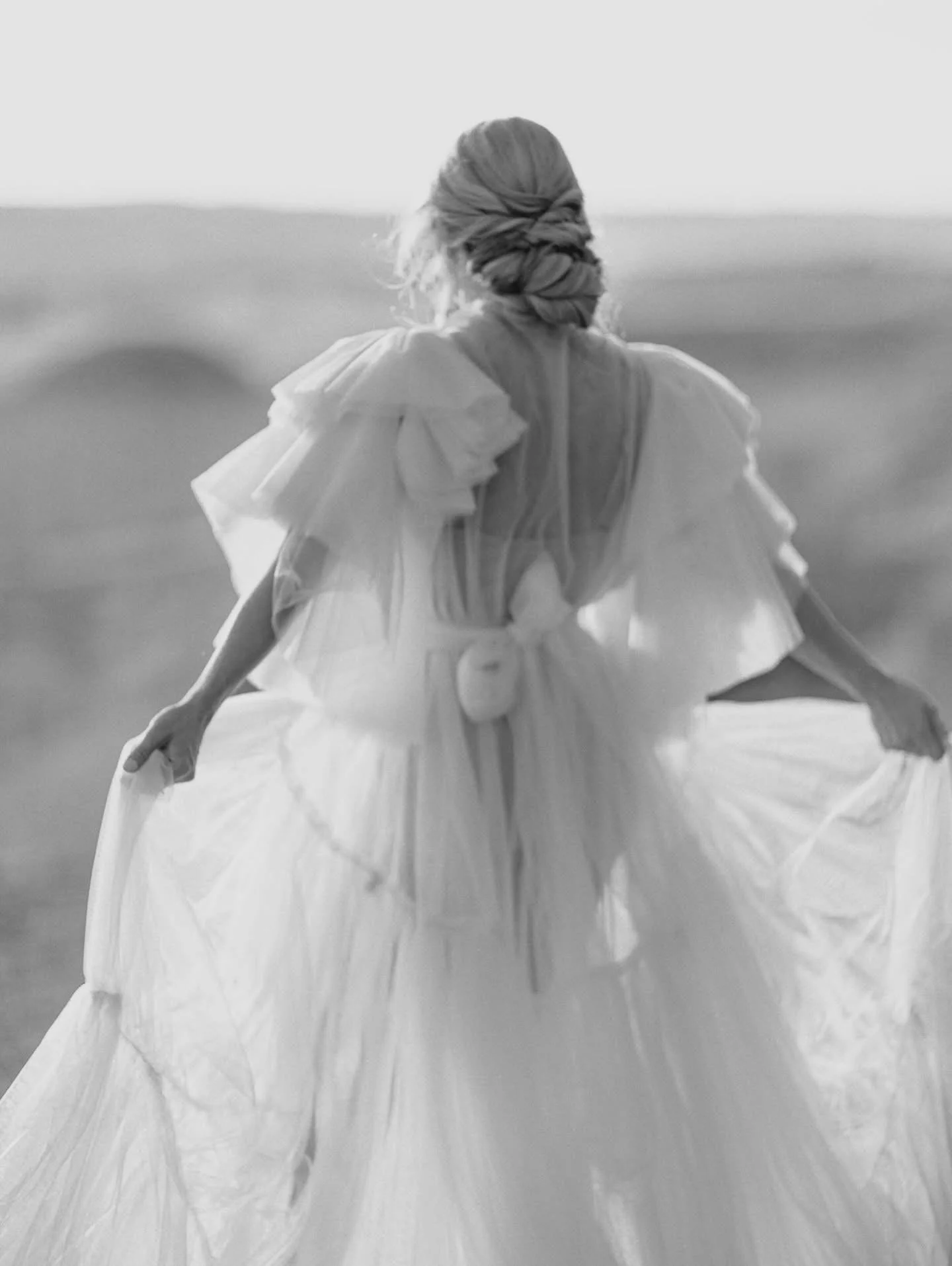 A woman in Drumheller Alberta wearing a fluffy pink gown robe with an open back, in a bridal photoshoot