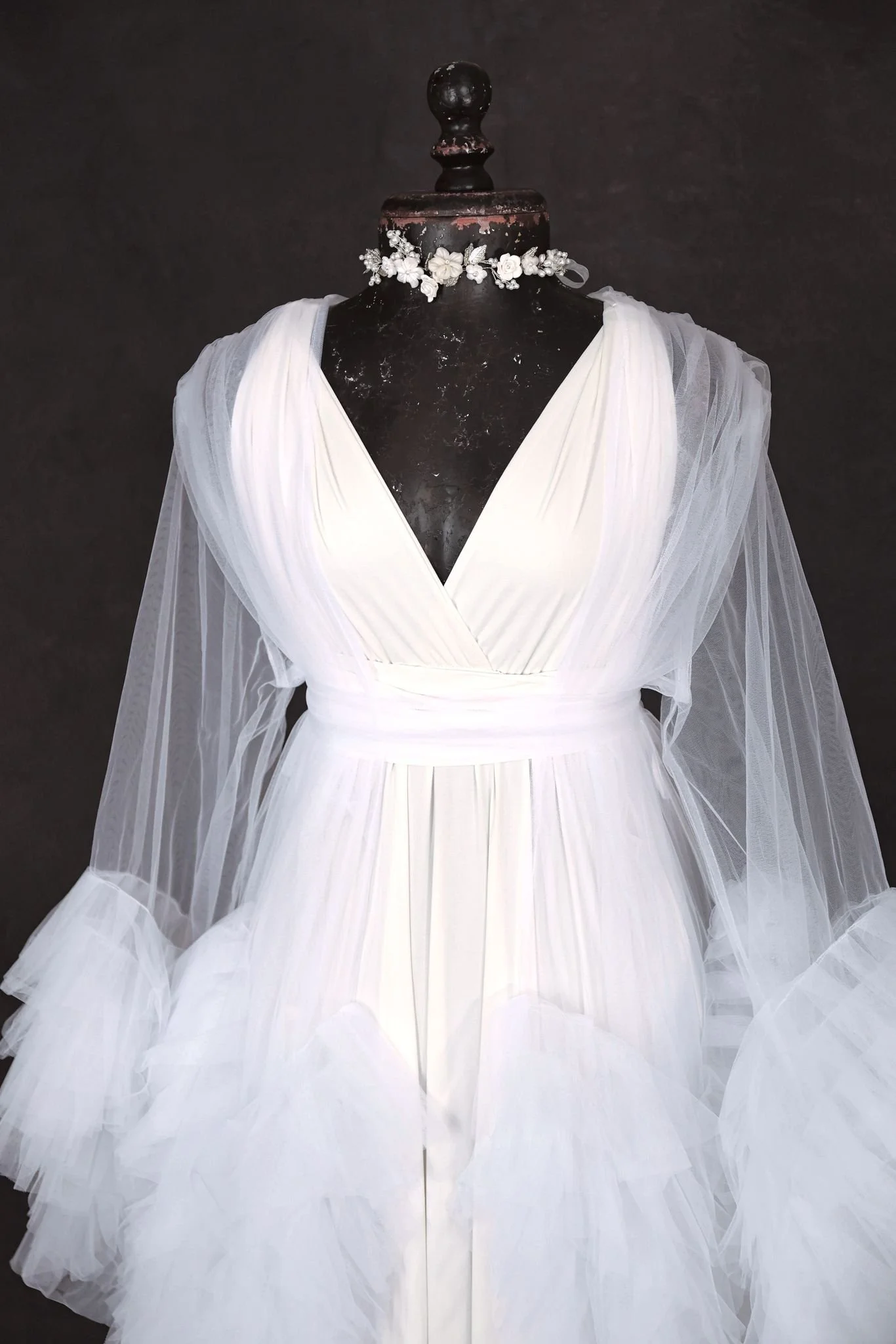 Close up of white infinity dress, with a sheer white tulle robe, and silver jewellery ribbon