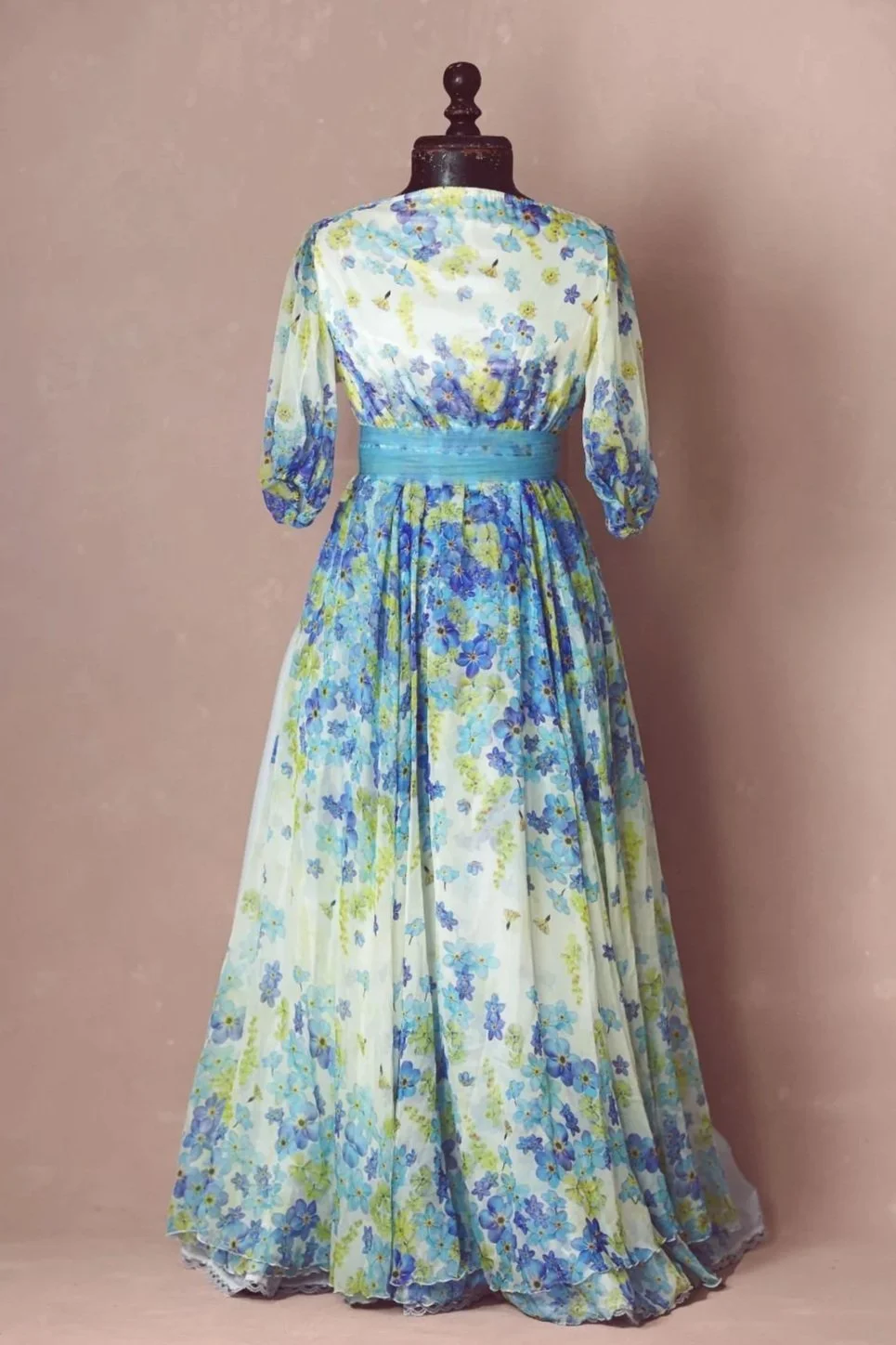 A white maxi dress with blue and yellow floral print, for maternity rentals and photoshoots