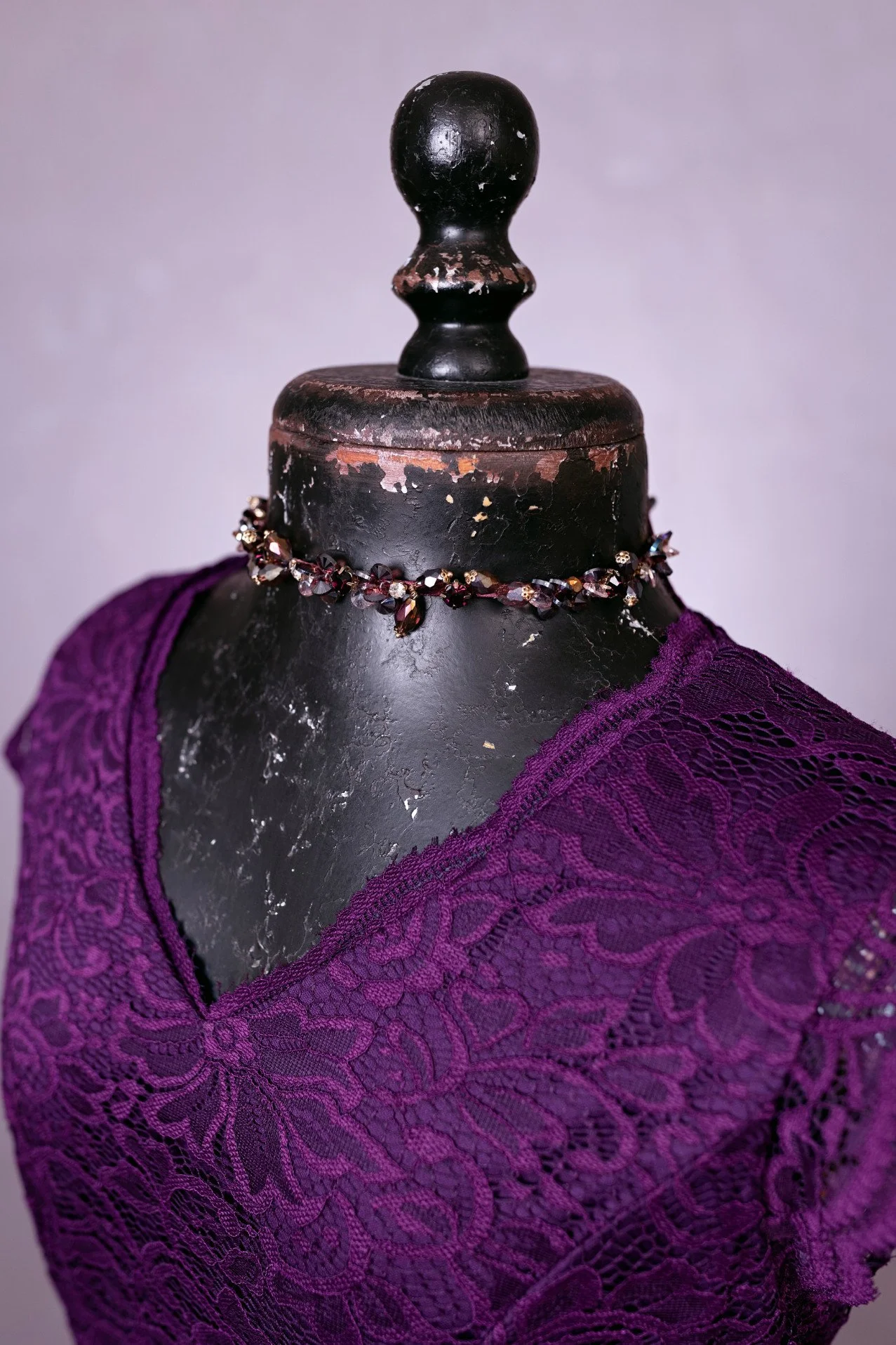 Close-up of dark purple dress, showing rhinestone jewellery accessory