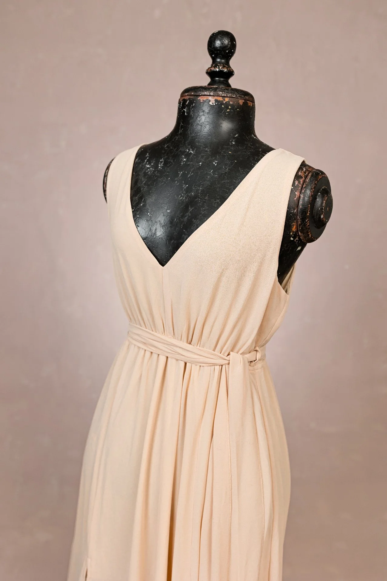 Close-up of cream beige maternity rental dress, showing v-neck and sleeveless design