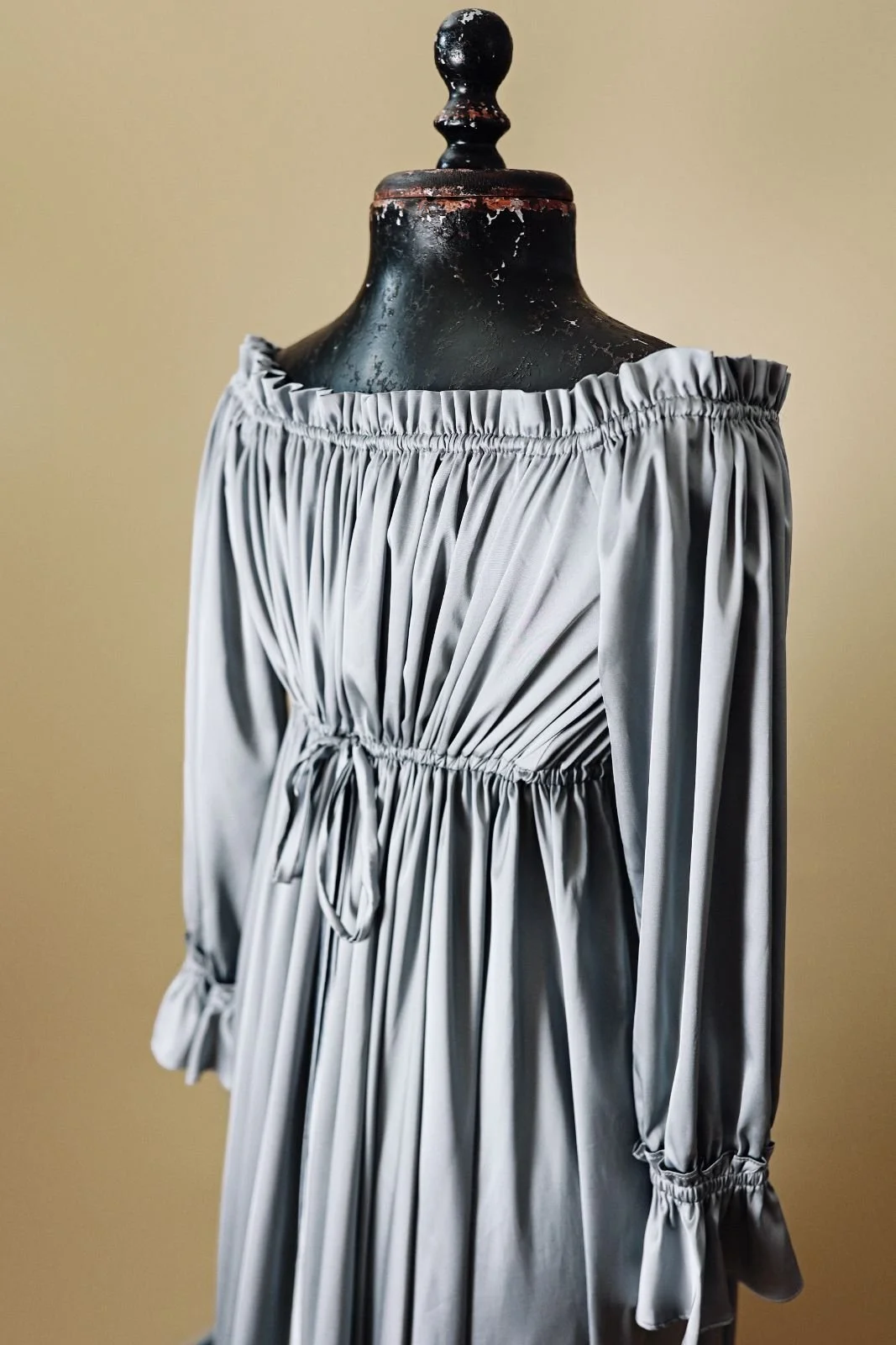 Back close up of silky grey gown, showing off-shoulder strapless desing
