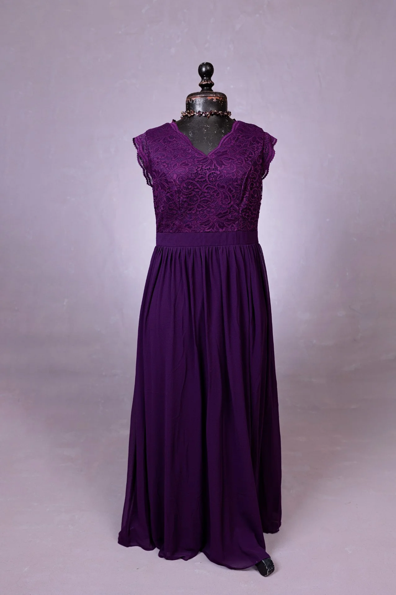 A dark purple sleeveless dress with lace corset and soft flowing skirt, for rent in Calgary