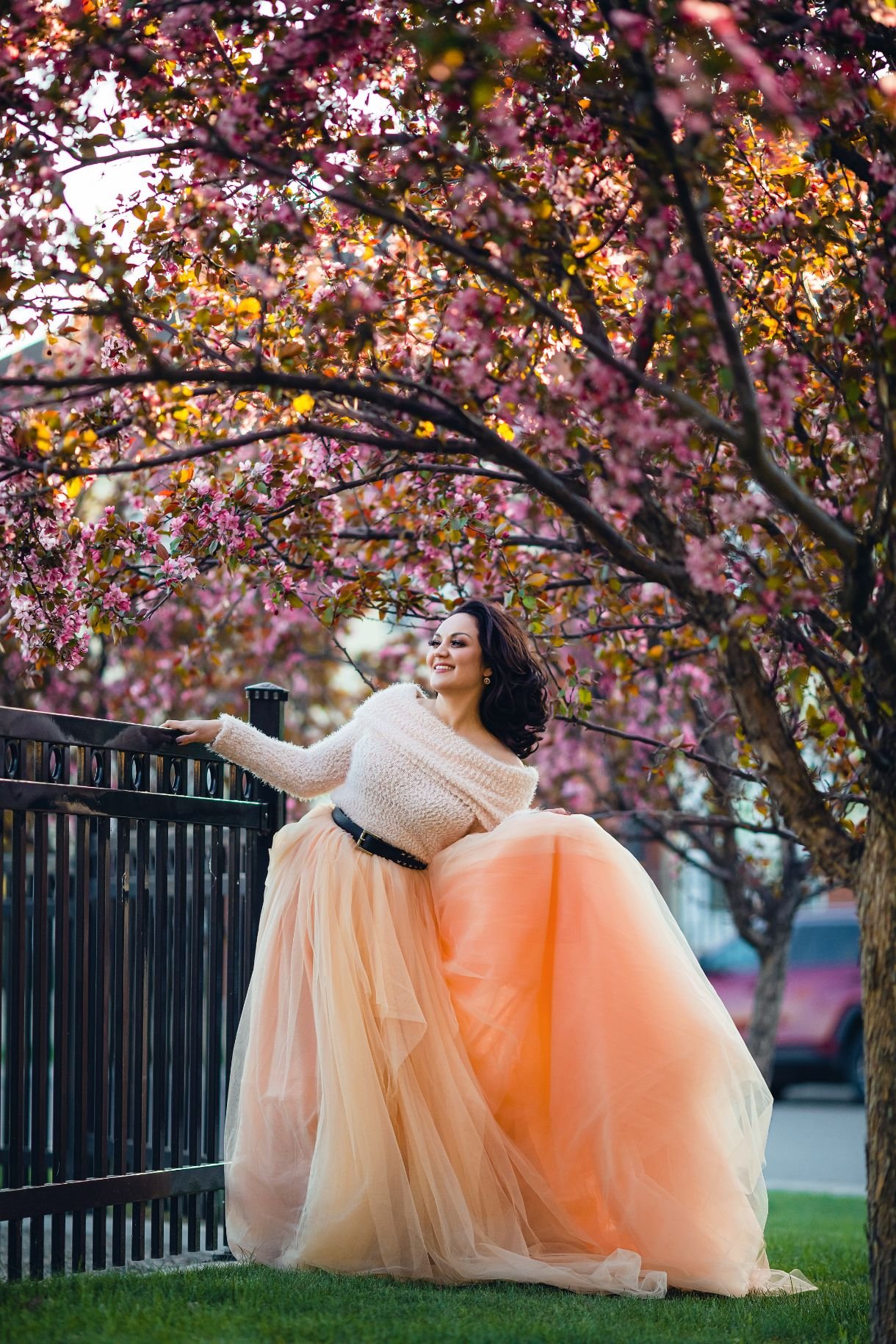 A woman wearing a light peach tulle skirt outfit in an outdoor spring photoshoot in Calgary