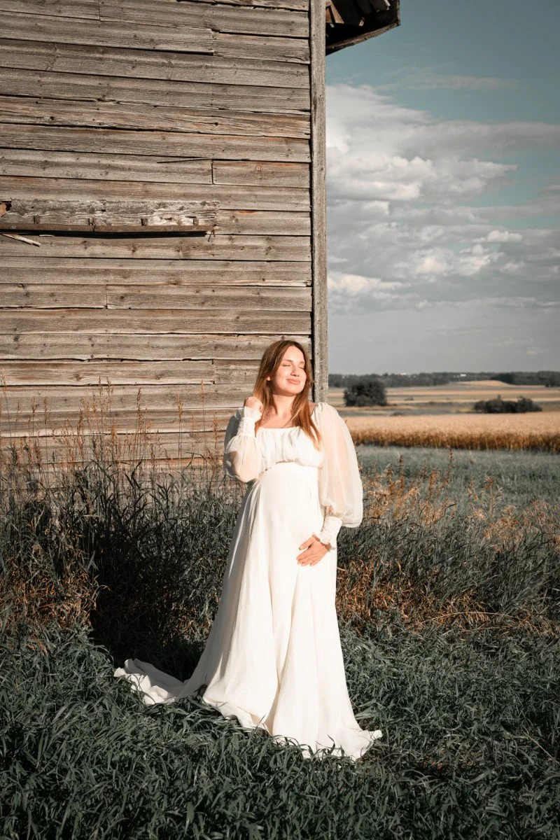 Pregnant woman wearing a boho vintage maternity dress in outdoor photoshoot